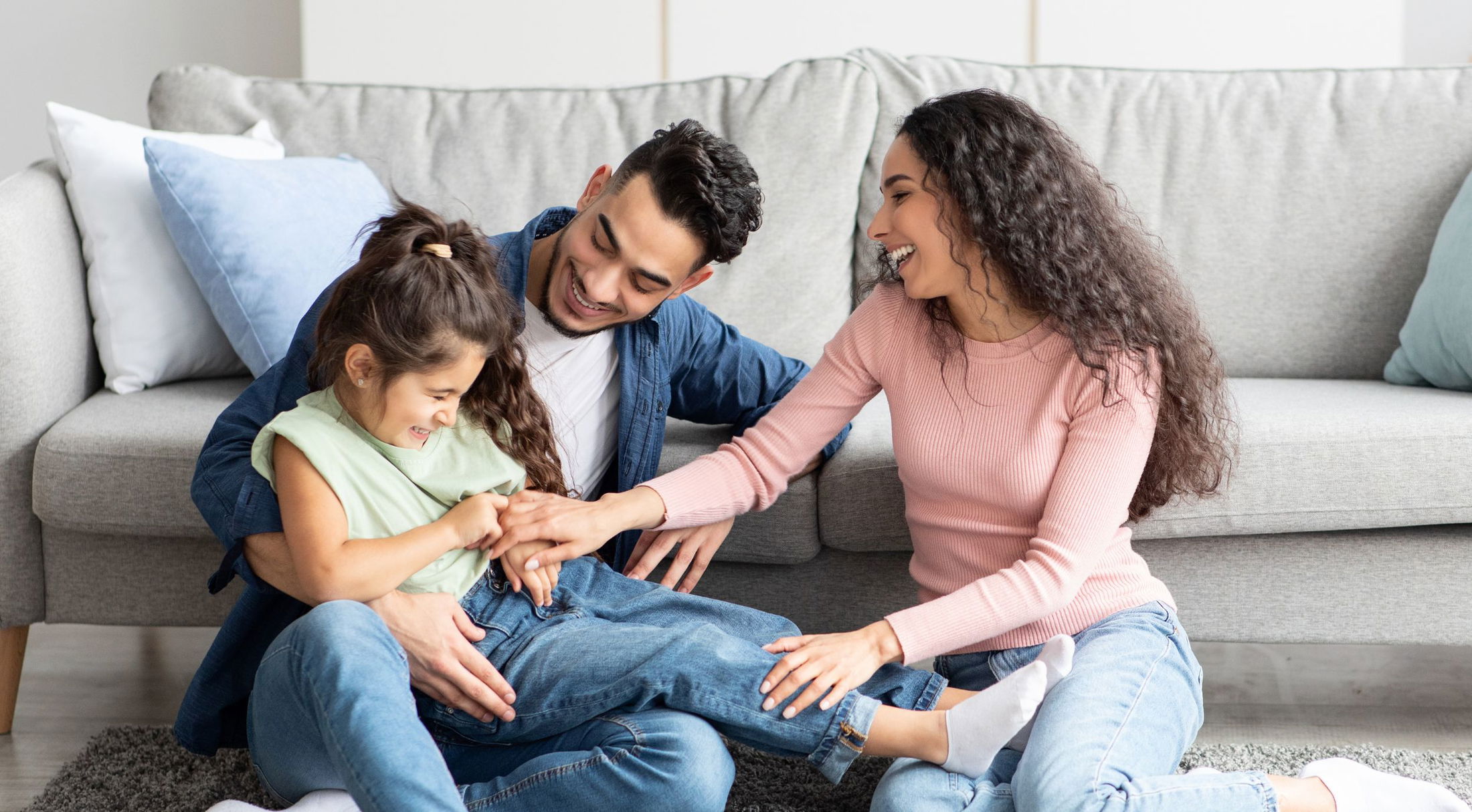 Happy family enjoying quality time together, laughing and playing on the living room floor.