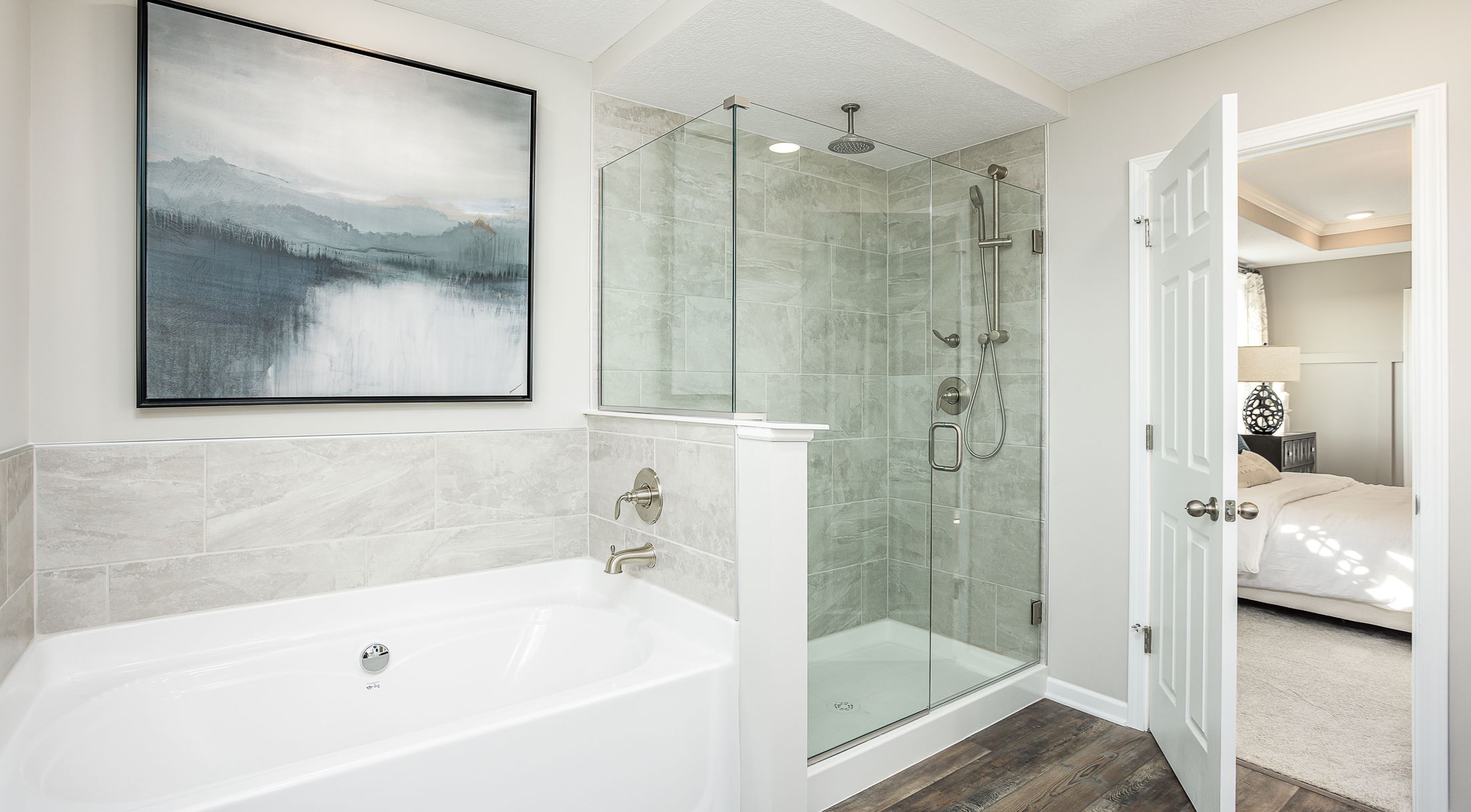 Modern bathroom with glass shower, freestanding bathtub, and stylish artwork on the wall.