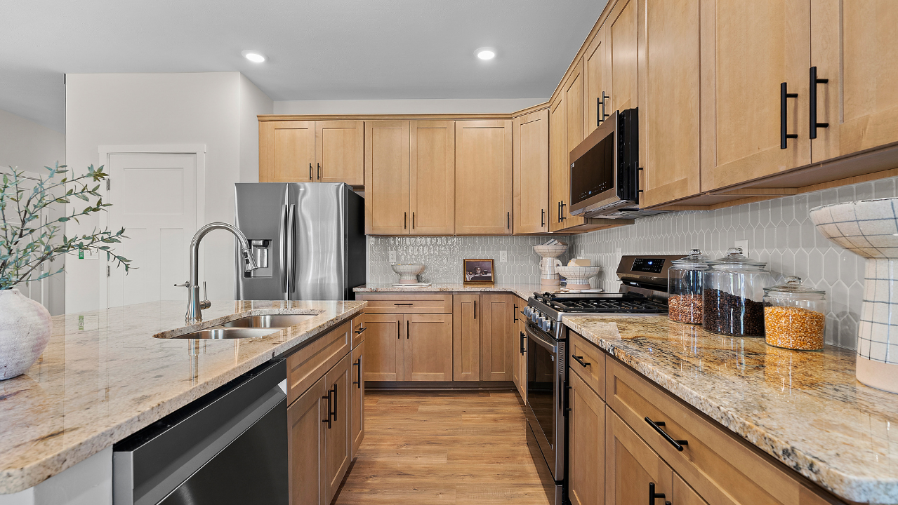 Modern kitchen with wooden cabinets, stainless steel appliances, and granite countertops.