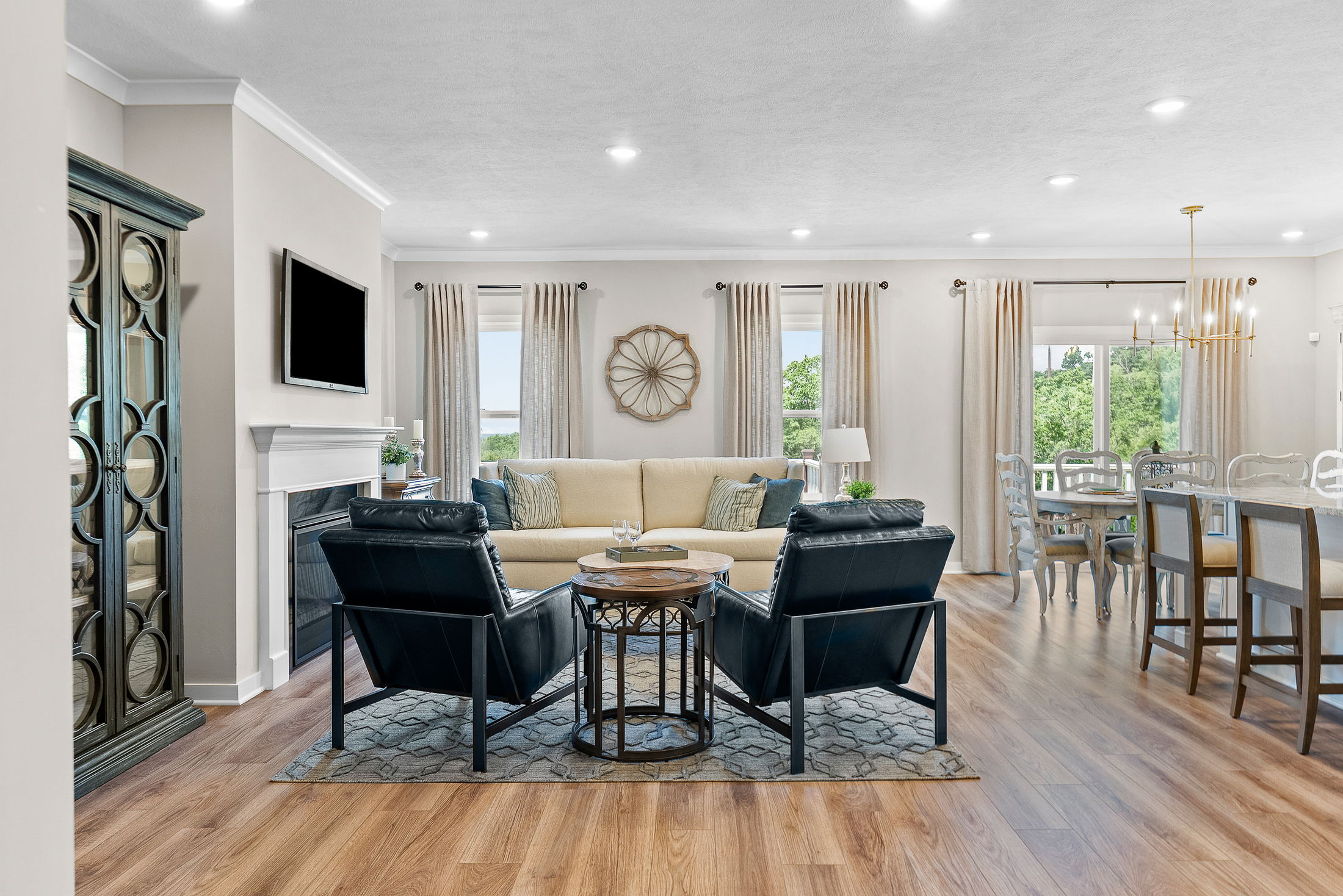 Elegant open-concept living and dining area with modern furniture and natural light streaming through large windows.