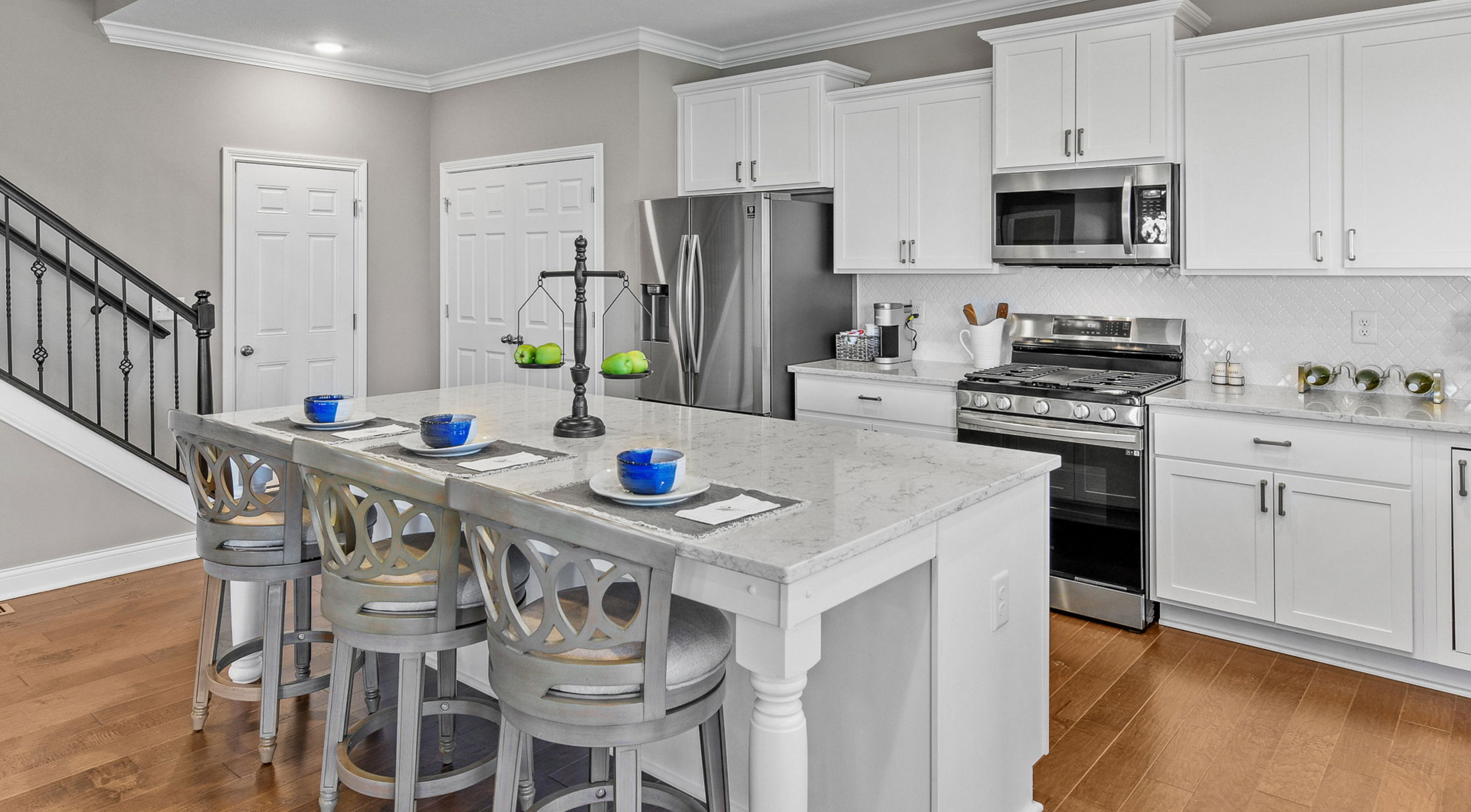 white kitchen with granite countertops and stainless appliances in a new home in West Jefferson