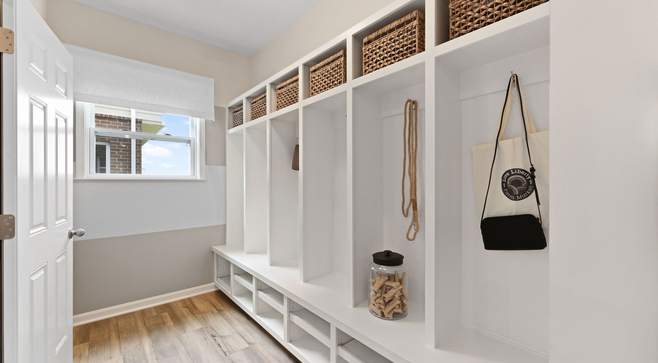 a mudroom cubby area with hooks and baskets
