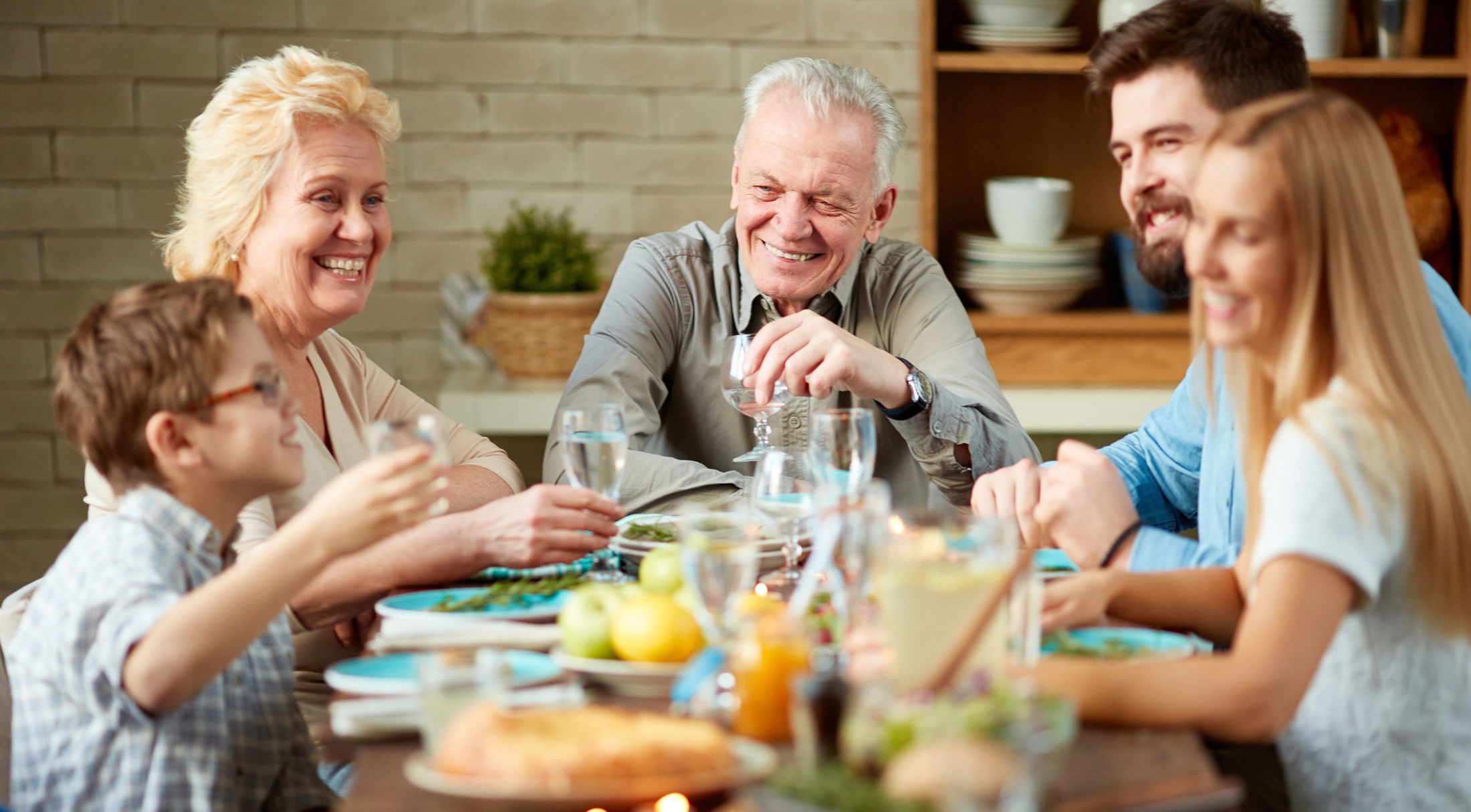 A joyful multigenerational family enjoying a meal together at a dining table, highlighting connection and happiness.