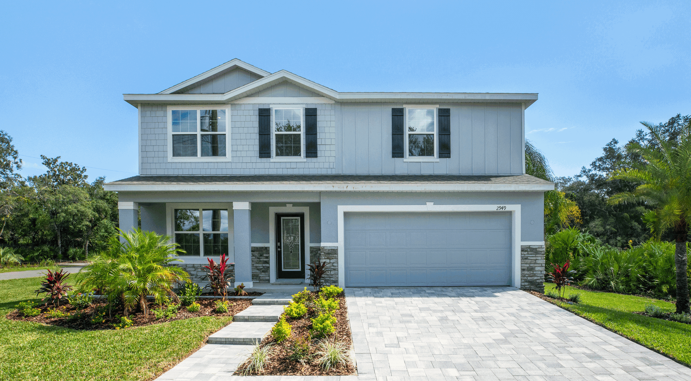 Modern two-story suburban house with landscaped yard and driveway in a serene neighborhood setting.