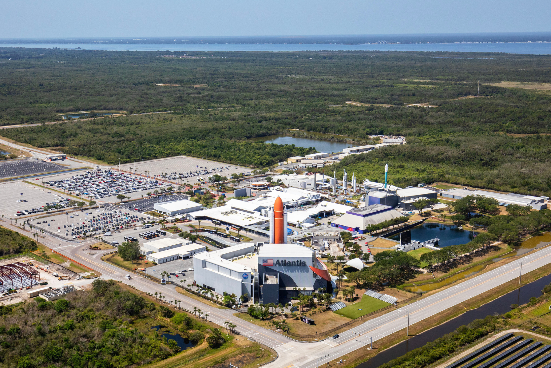 Aerial view of the Kennedy Space Center Visitor Complex in Florida, showcasing the Space Shuttle Atlantis exhibit and surrounding landscape.