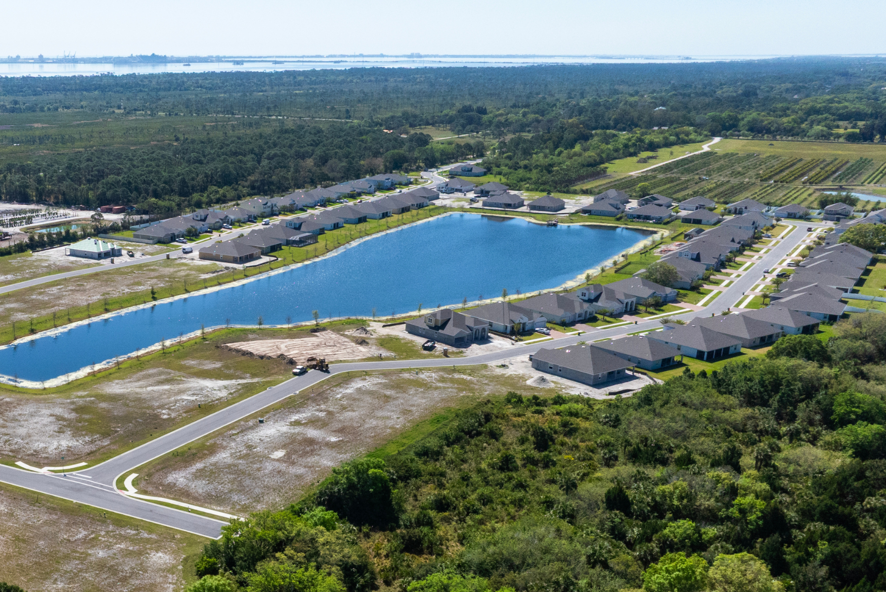 Aerial view of a residential neighborhood with a central lake surrounded by houses and greenery.