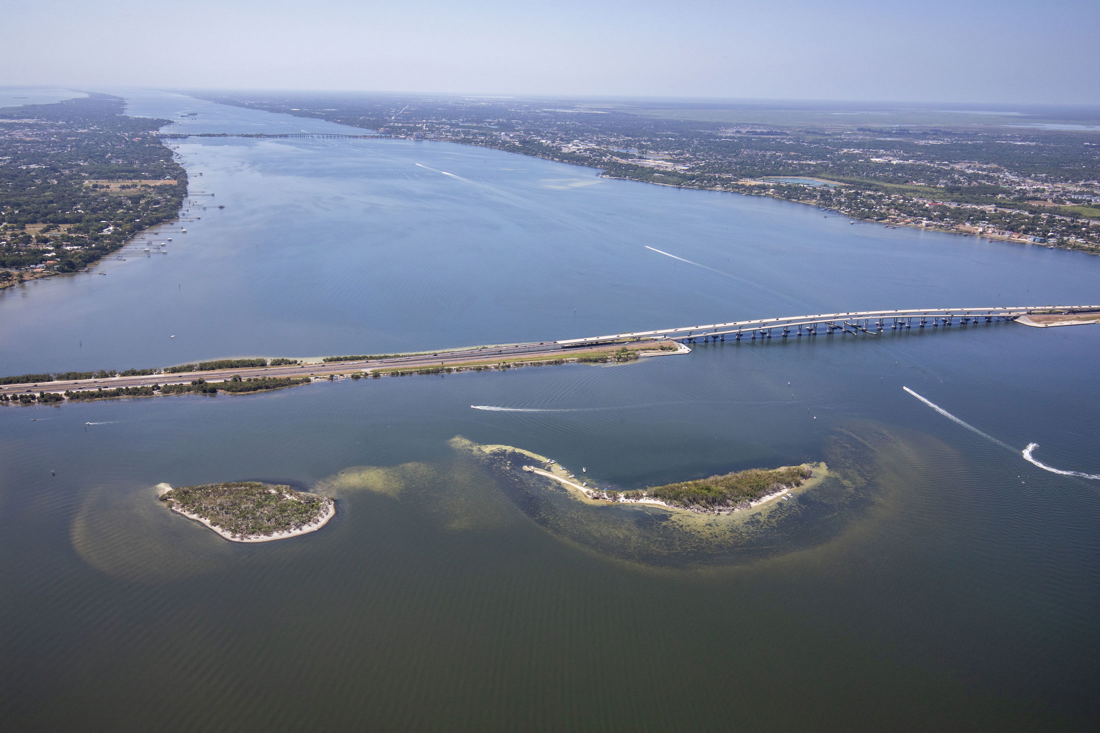 Aerial view of Causeway Islands Park in Florida, showcasing a scenic waterway, lush greenery, and a prominent bridge.
