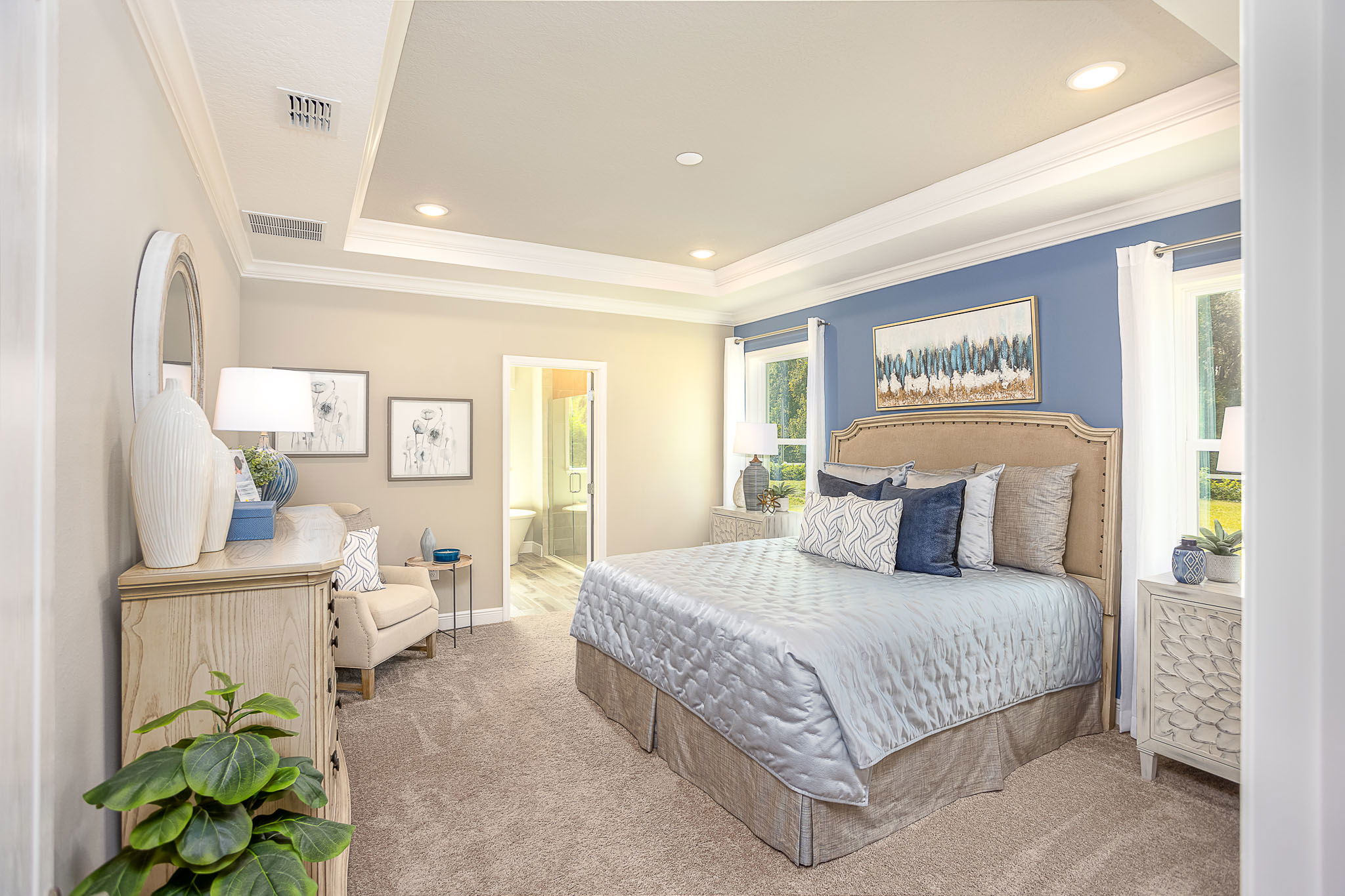 Luxurious and serene bedroom with blue accent wall, elegant bedding, and stylish decor in a well-lit interior space.