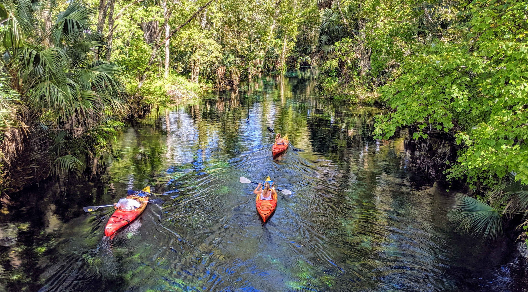 three people kayaking down a river in poe springs