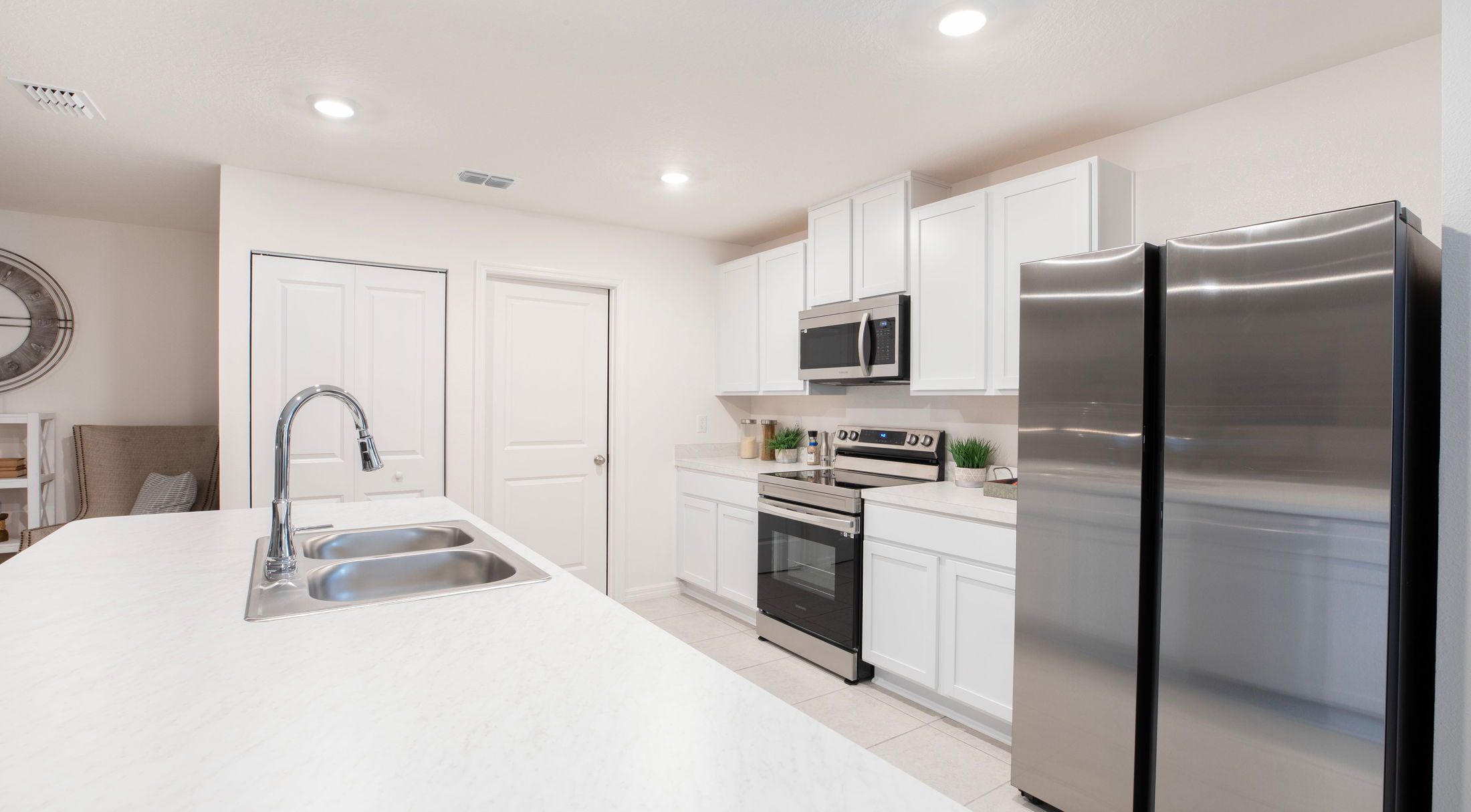 Modern kitchen interior with stainless steel appliances, white cabinets, and a sleek countertop.