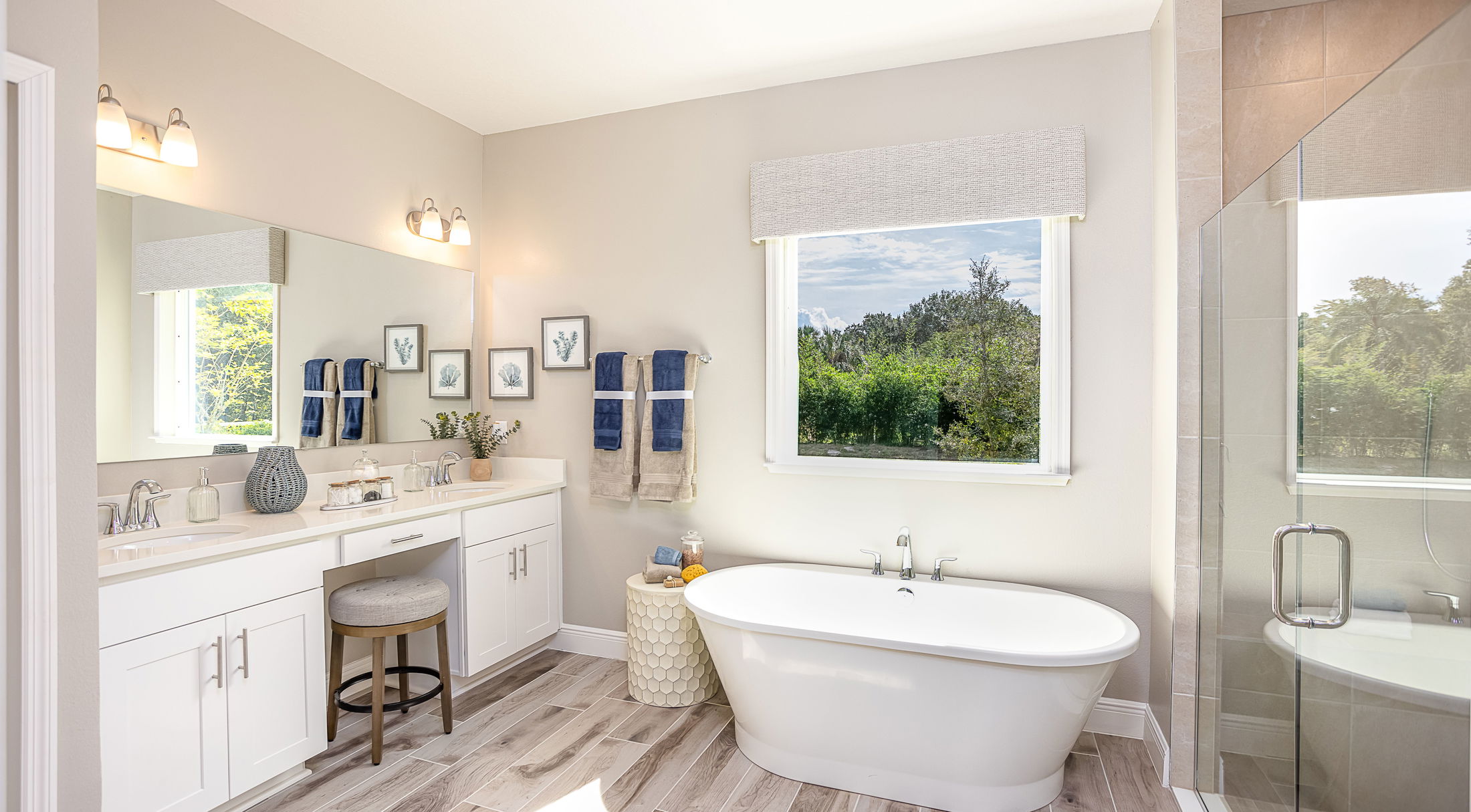 Bright and modern bathroom design featuring a freestanding bathtub, double sink vanity, and large window with a serene view.
