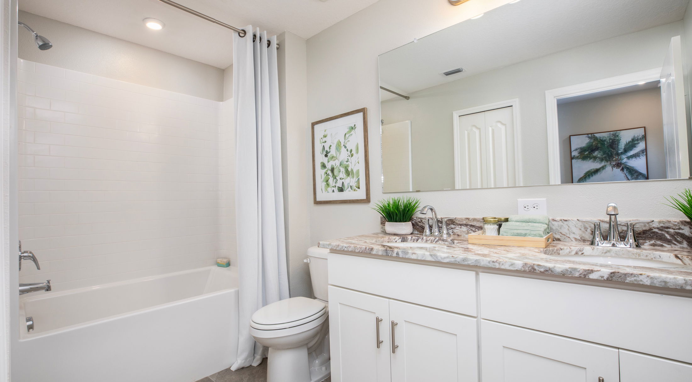 Modern bathroom with a white bathtub, marble countertop, and stylish decor.