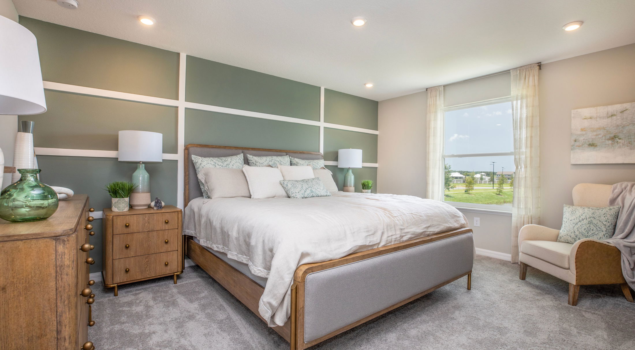 Modern bedroom with a comfortable bed, stylish decor, and natural light streaming through a large window.