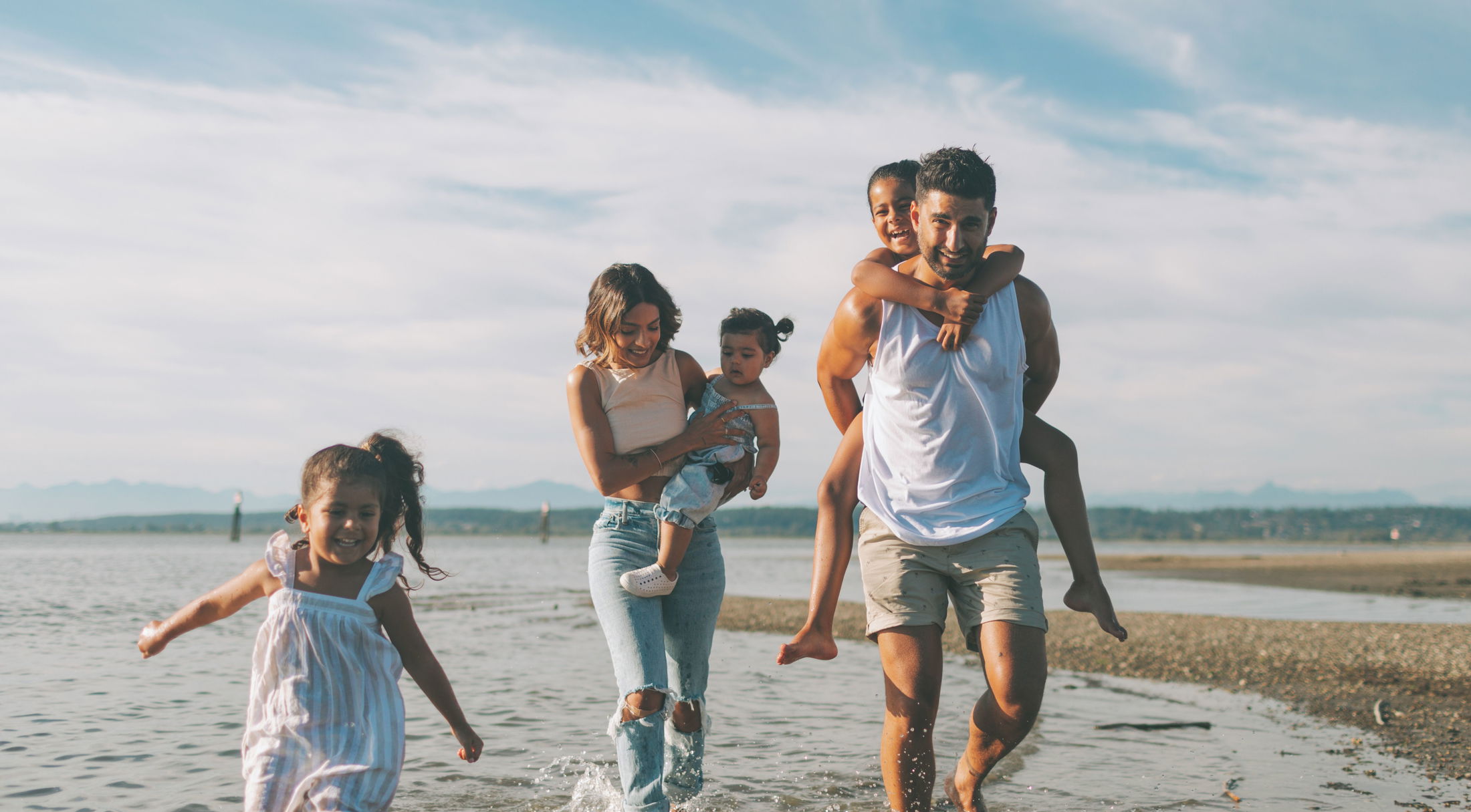 Family of five running along a beach near Port Charlotte, FL