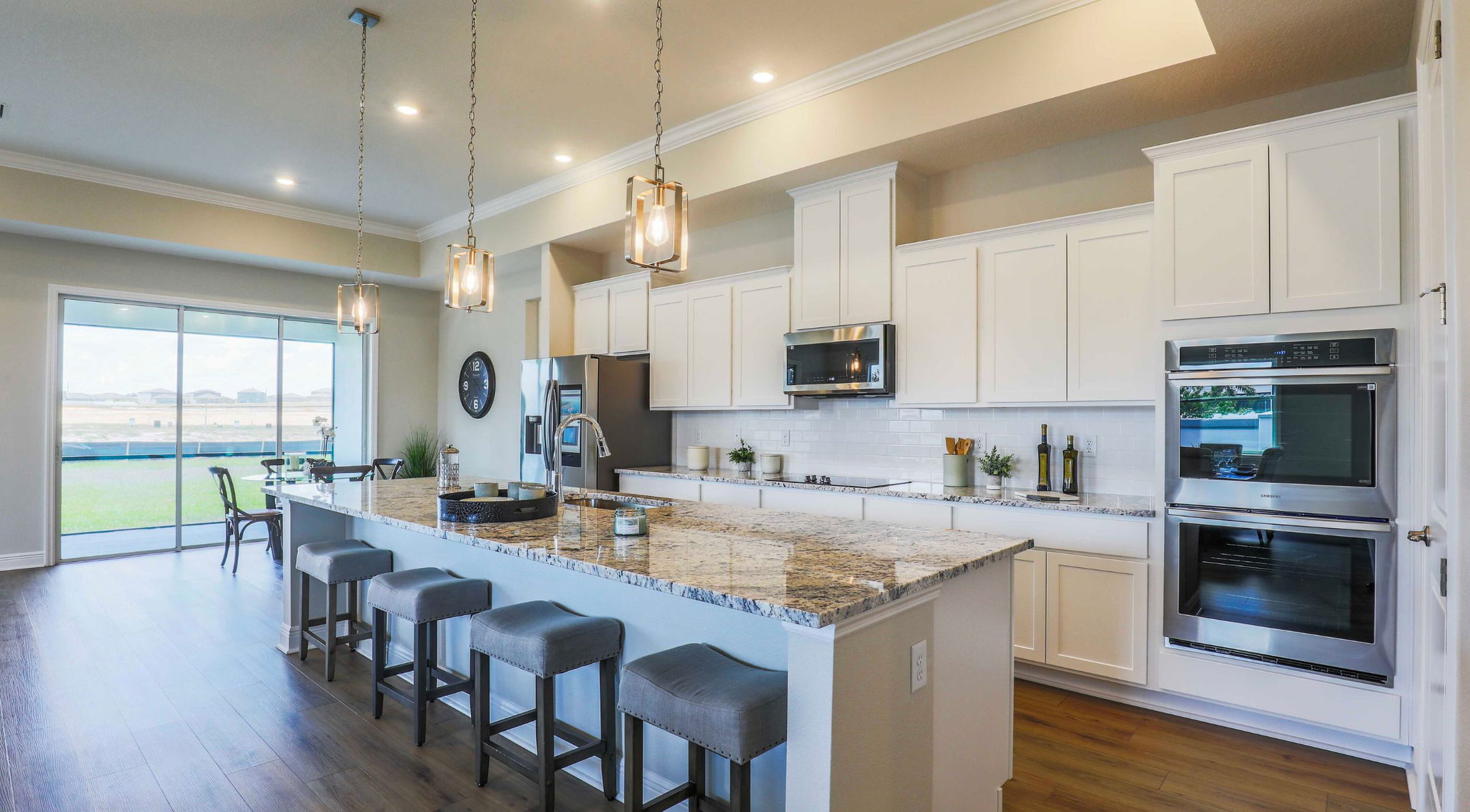 galley style white kitchen with stainless appliances in a new home in lakeland, fl