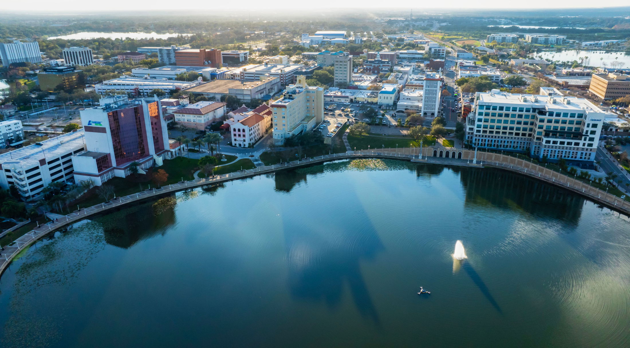 Aerial view of Lakeland, Florida\\\\\\\'s downtown skyline with buildings surrounding Lake Mirror.