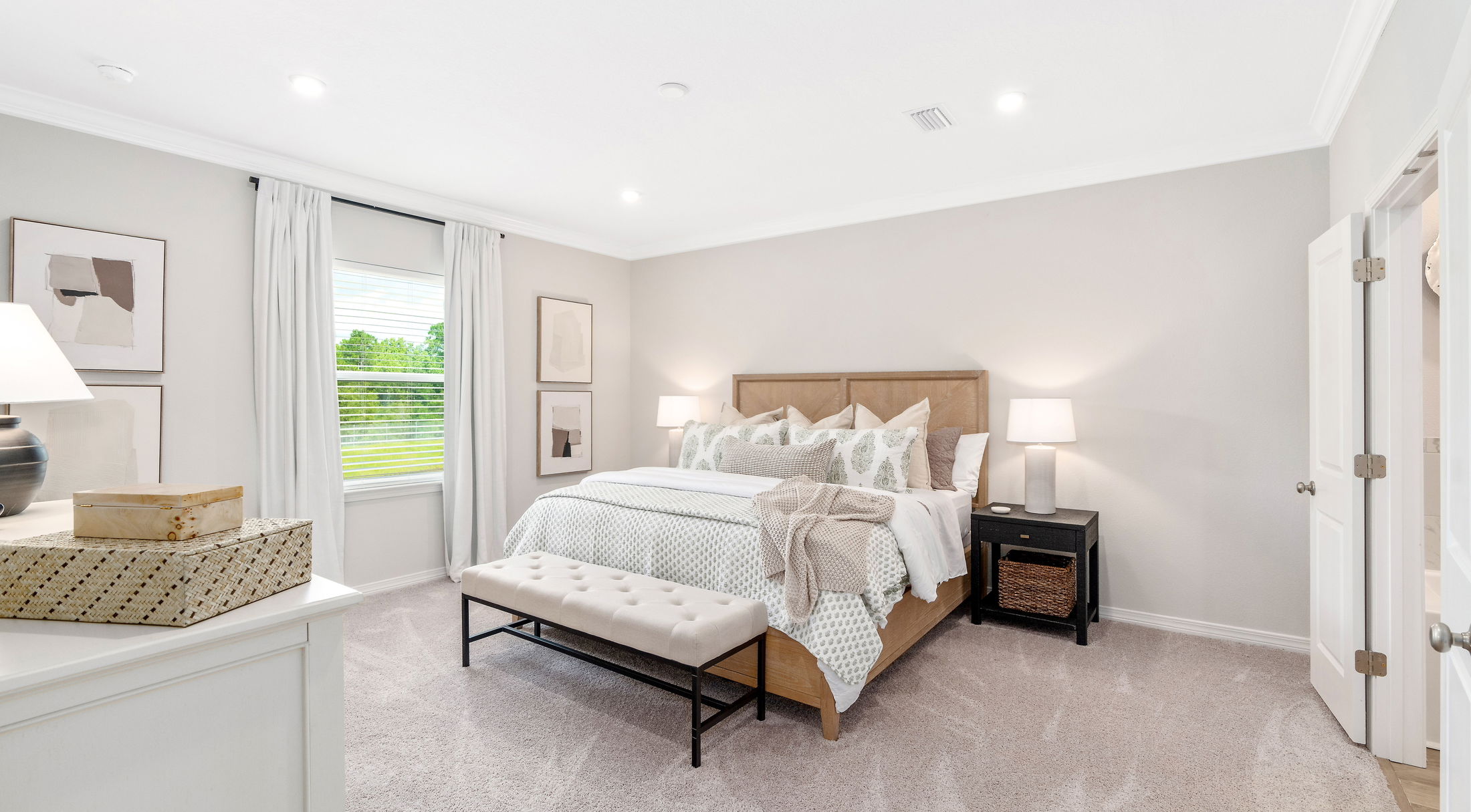 Stylish modern bedroom with neutral tones, featuring a wooden bed, cushioned bench, and elegant decor.