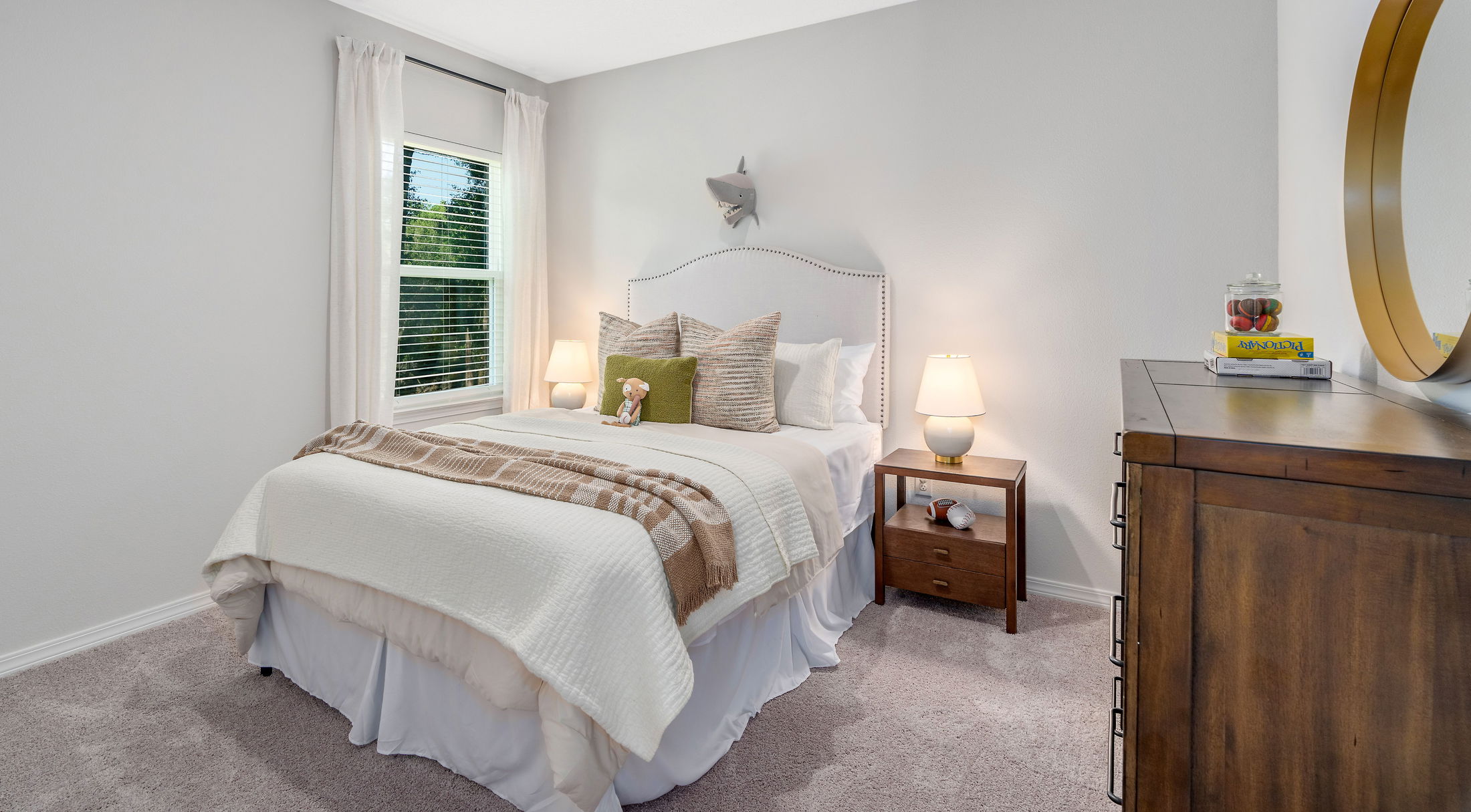 Cozy, modern bedroom with a plush bed, wooden dresser, and soft lighting creating a warm ambiance.
