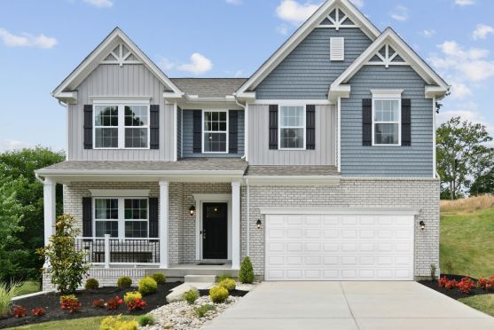 "Beautiful two-story suburban home with blue and gray siding, manicured landscaping, and a double garage."