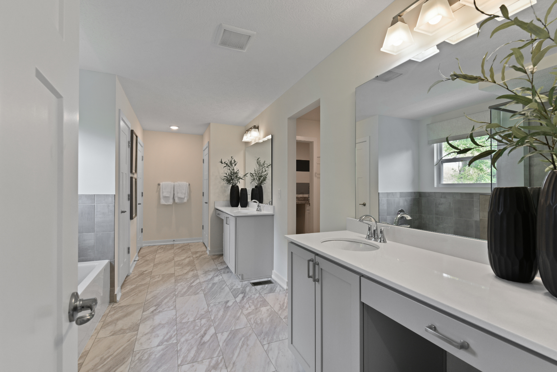 Modern bathroom with dual sinks, large mirror, tiled flooring, and minimalistic decor.