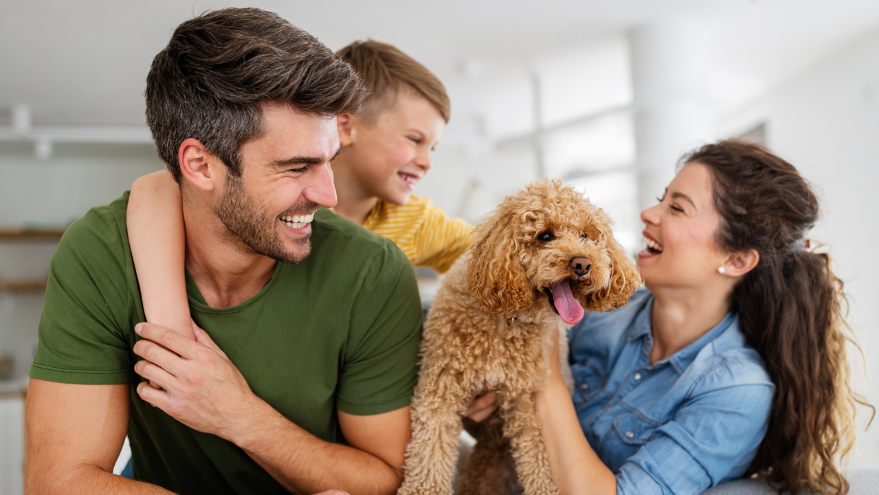Happy family enjoying quality time at home with their cheerful dog.