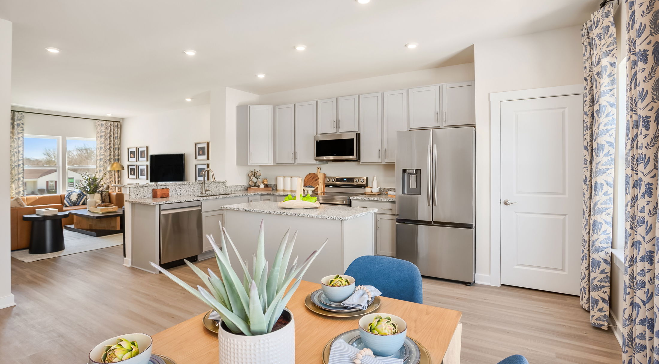 Modern open-concept kitchen and dining area with stainless steel appliances and elegant decor.