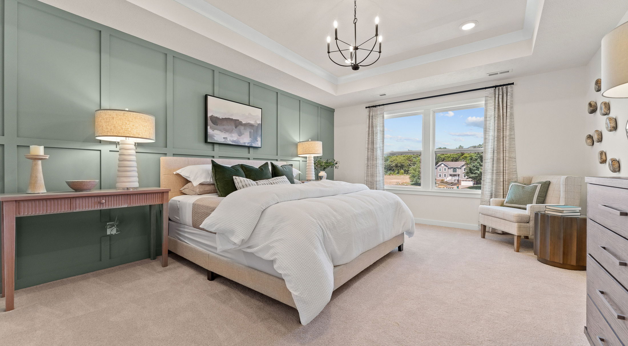 Elegant bedroom with green accent wall, large window, and cozy decor featuring a neatly made bed with white linens and stylish lighting.
