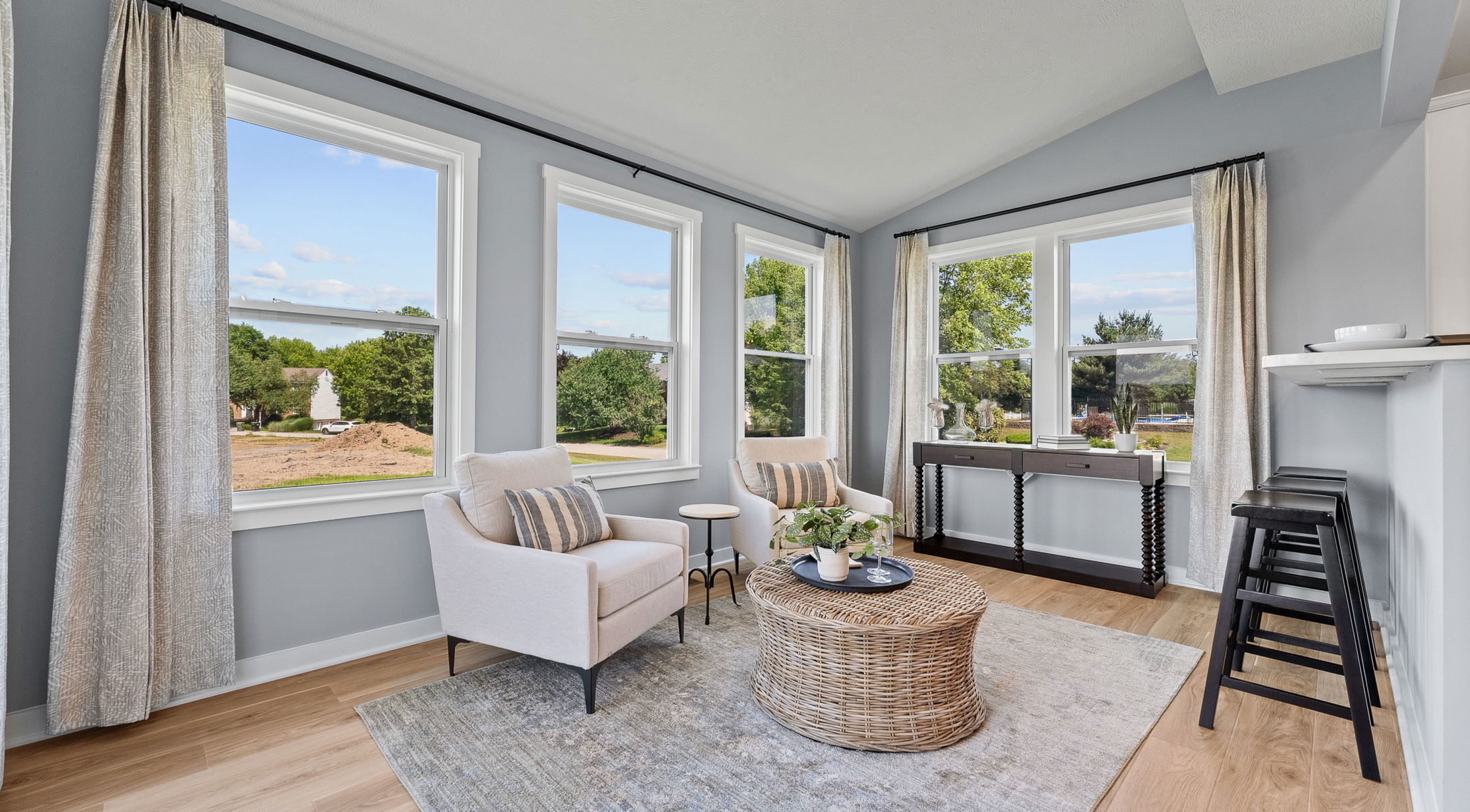 Bright and airy living room with large windows, modern furniture, and stylish decor elements.