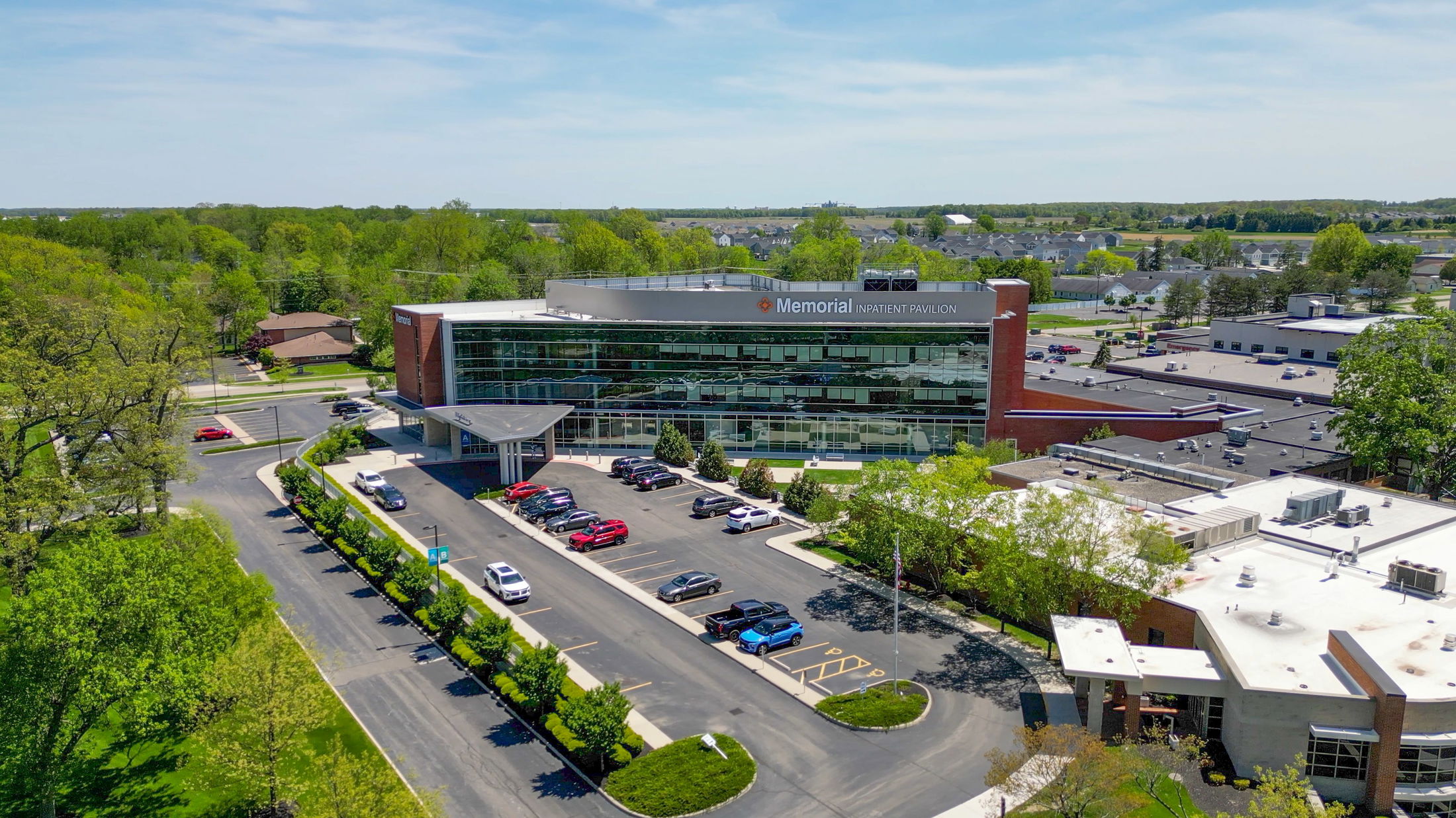 Aerial view of Memorial Inpatient Pavilion surrounded by lush greenery and parking areas.