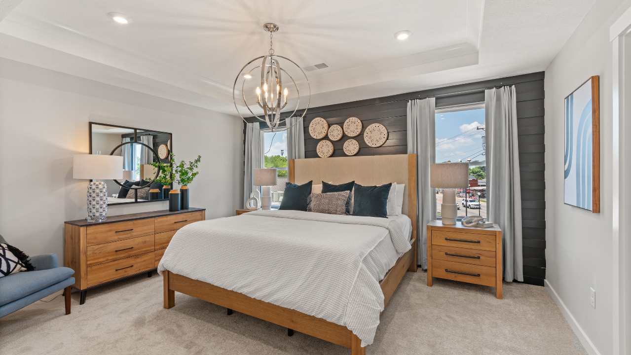 Modern bedroom with stylish wooden furniture, decorative wall accents, and a large chandelier illuminating the space.