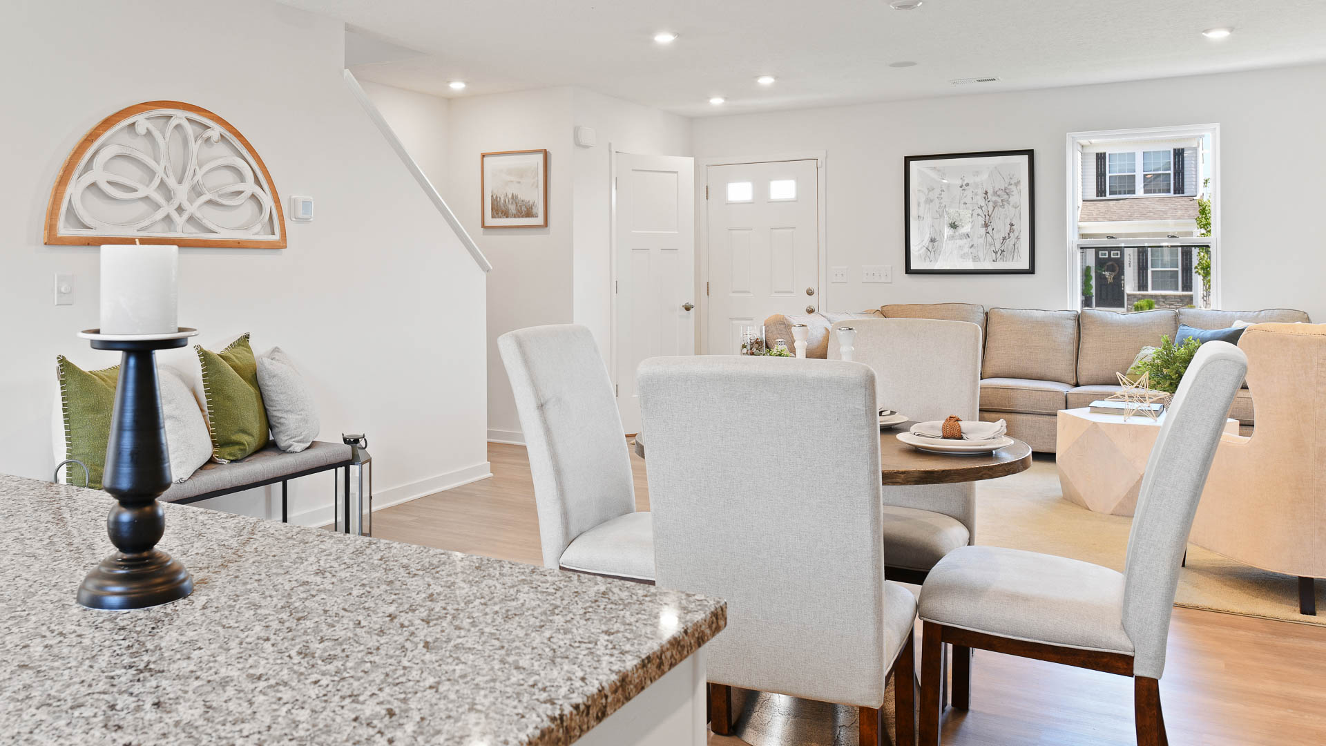 Modern open-concept living and dining area with neutral tones and elegant decor.