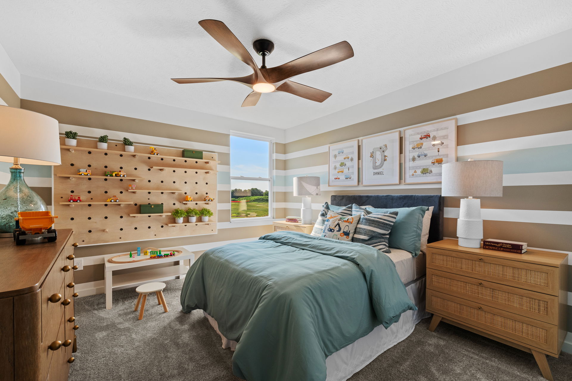 Children's bedroom with a striped wall, wooden furniture, and a pegboard featuring toys and plants.