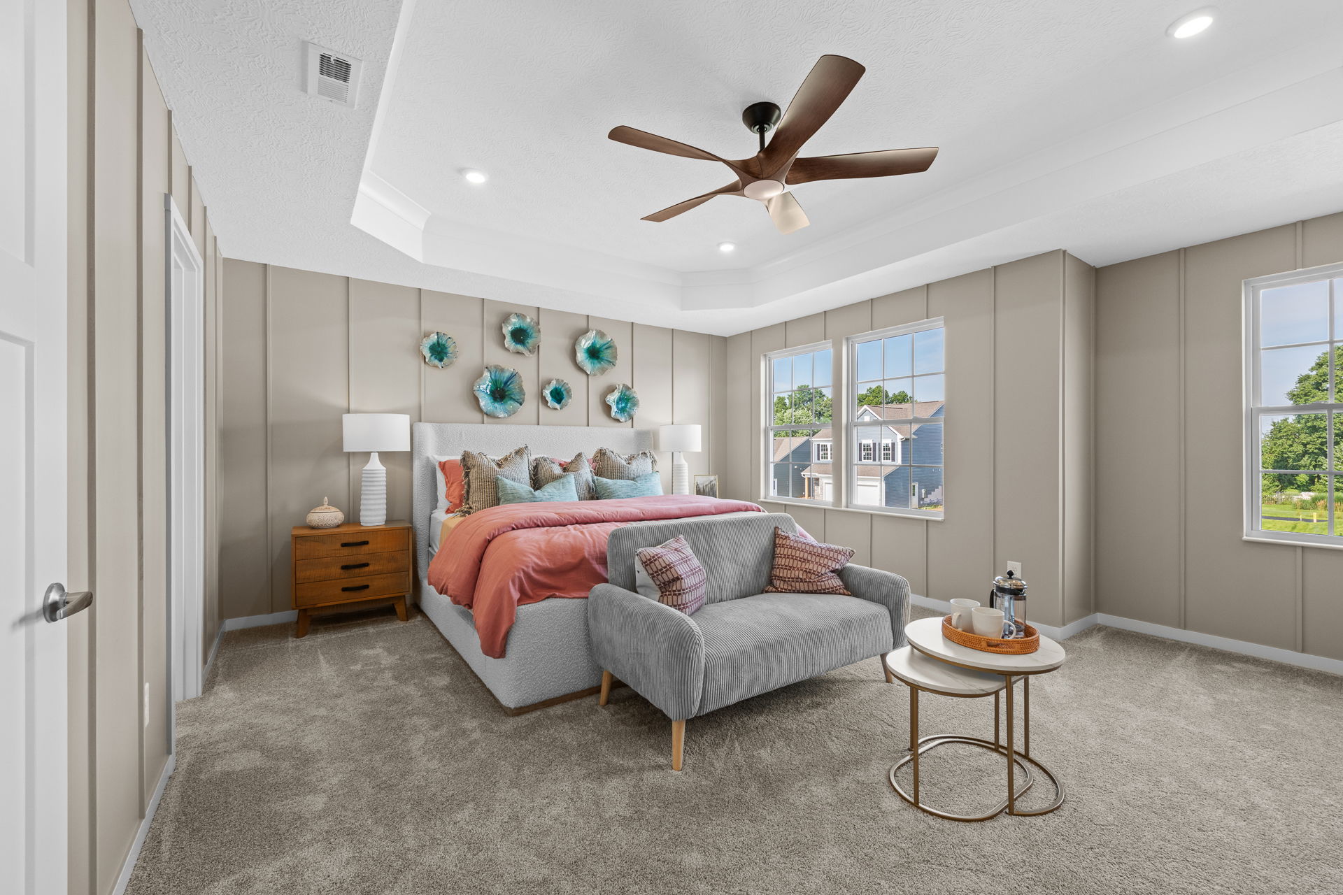 Elegant modern bedroom with stylish decor, featuring a cozy bed, colorful cushions, and airy windows.