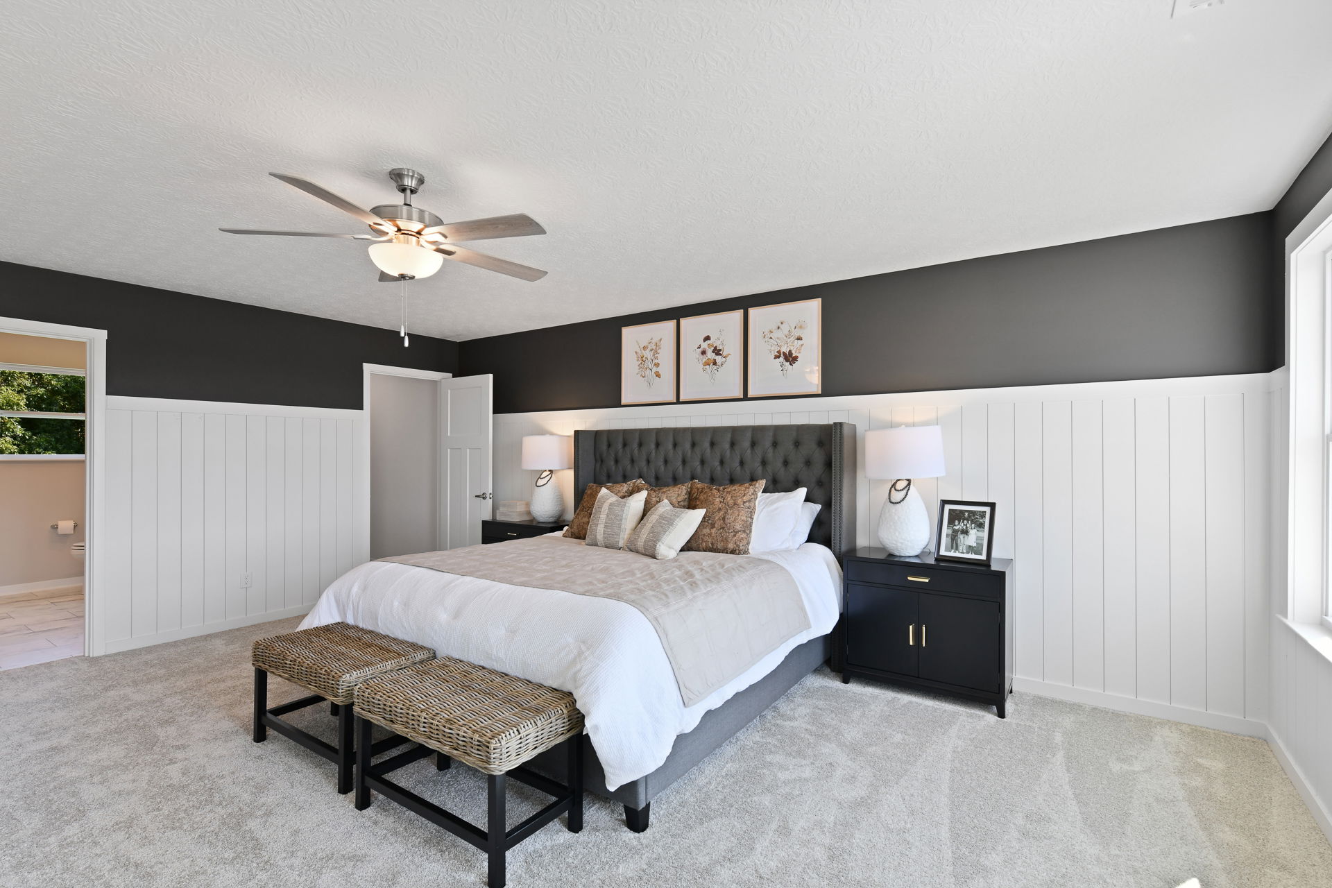 Modern bedroom with tufted headboard, stylish lamps, and neutral decor accents.