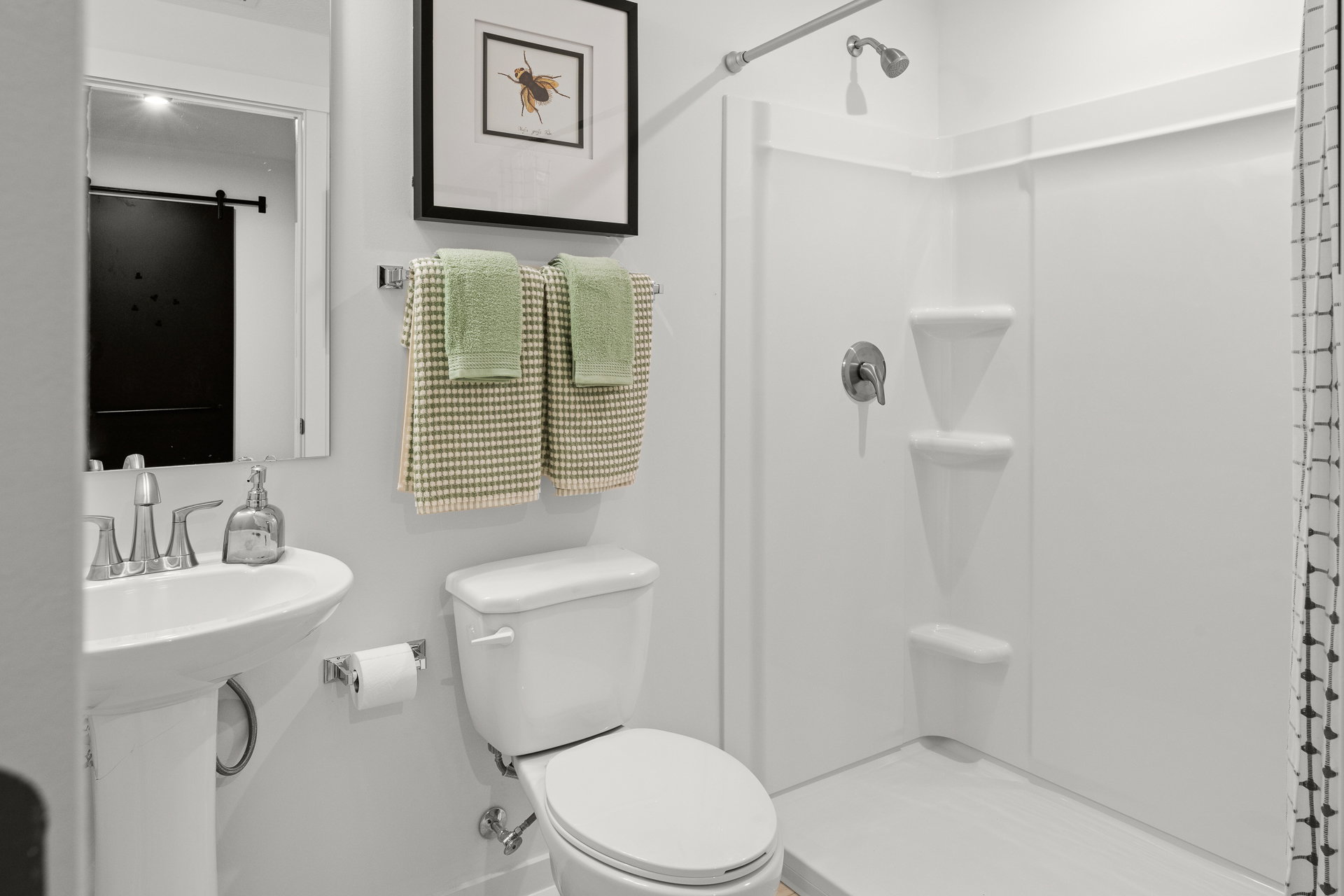 A modern bathroom featuring a shower, toilet, sink, and decorative towels.