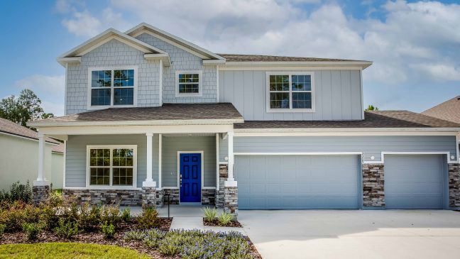 Modern two-story suburban house with blue accents, a three-car garage, and a landscaped front yard.