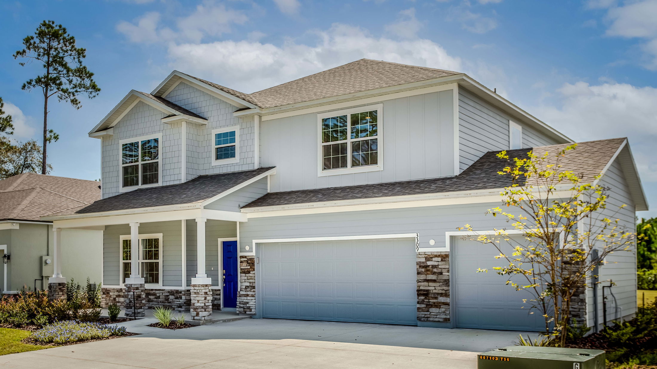 Two-story modern suburban house with gray siding, blue front door, and double garage.