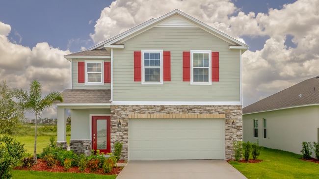 Contemporary two-story house with red shutters, stone accents, and a manicured lawn under a partly cloudy sky.