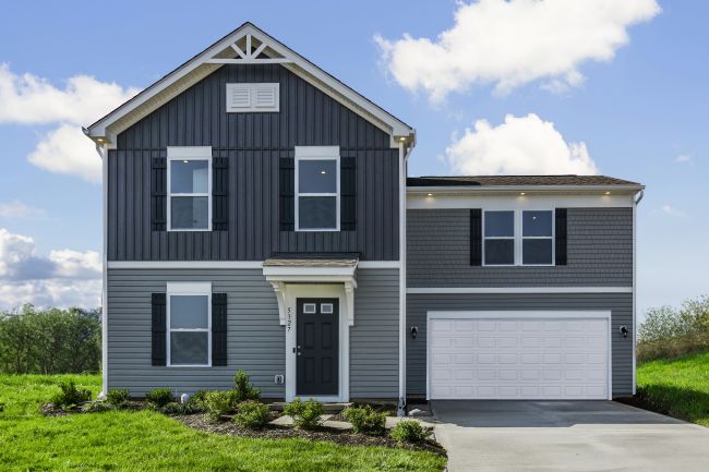 Modern two-story gray house with black shutters, white trim, and a double garage door, surrounded by green grass and a clear blue sky.