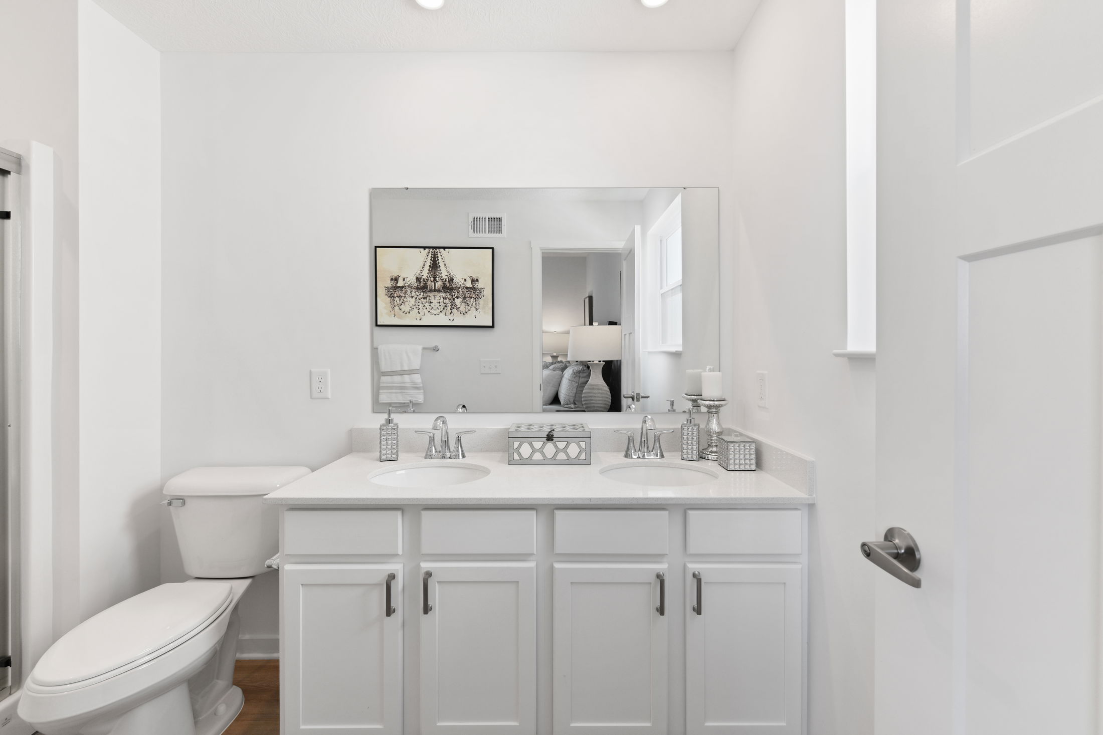 Modern bathroom with a double vanity, white cabinets, and elegant decor.