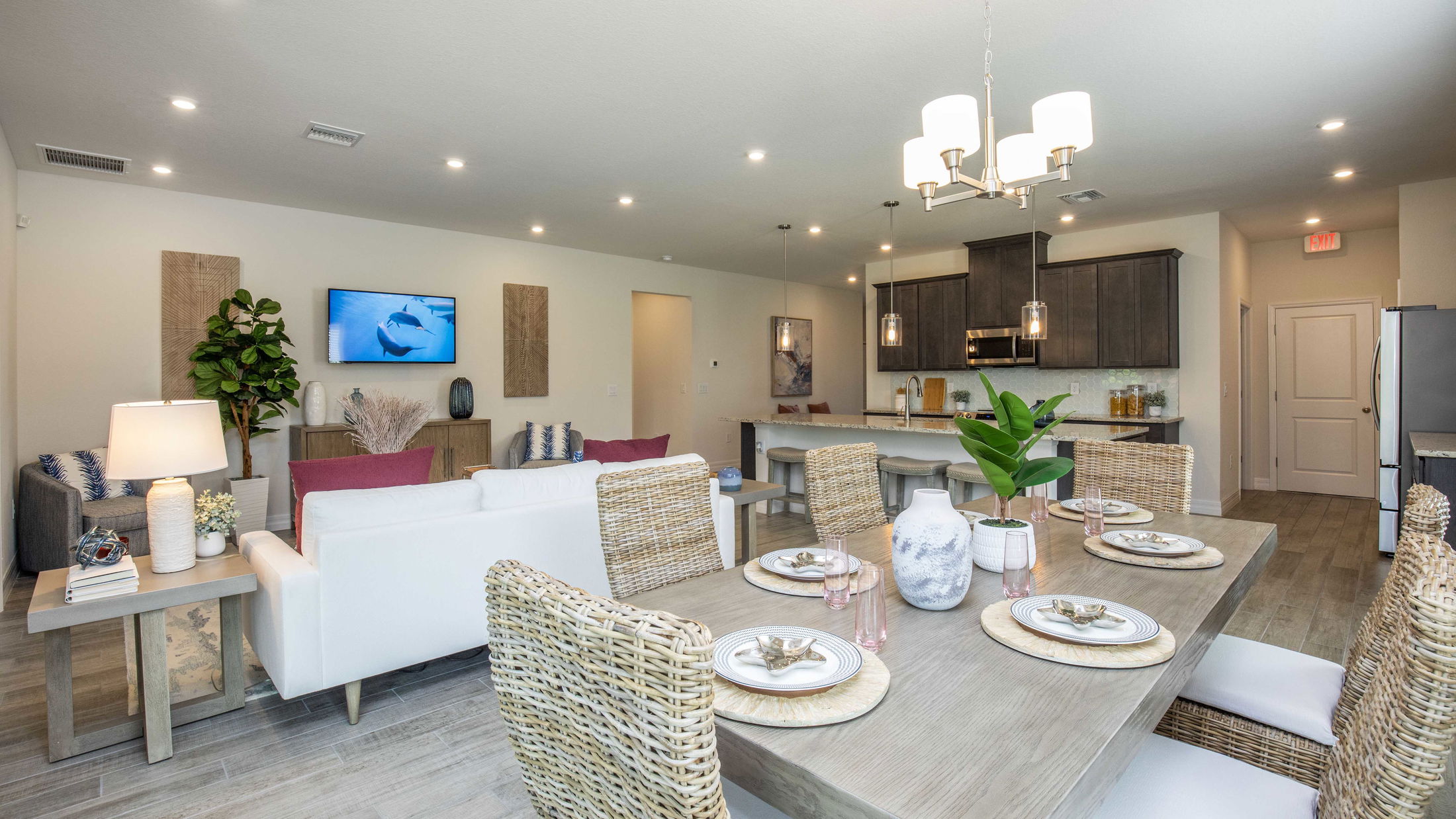 Modern open-concept living and dining area with contemporary decor and a spacious kitchen in the background.