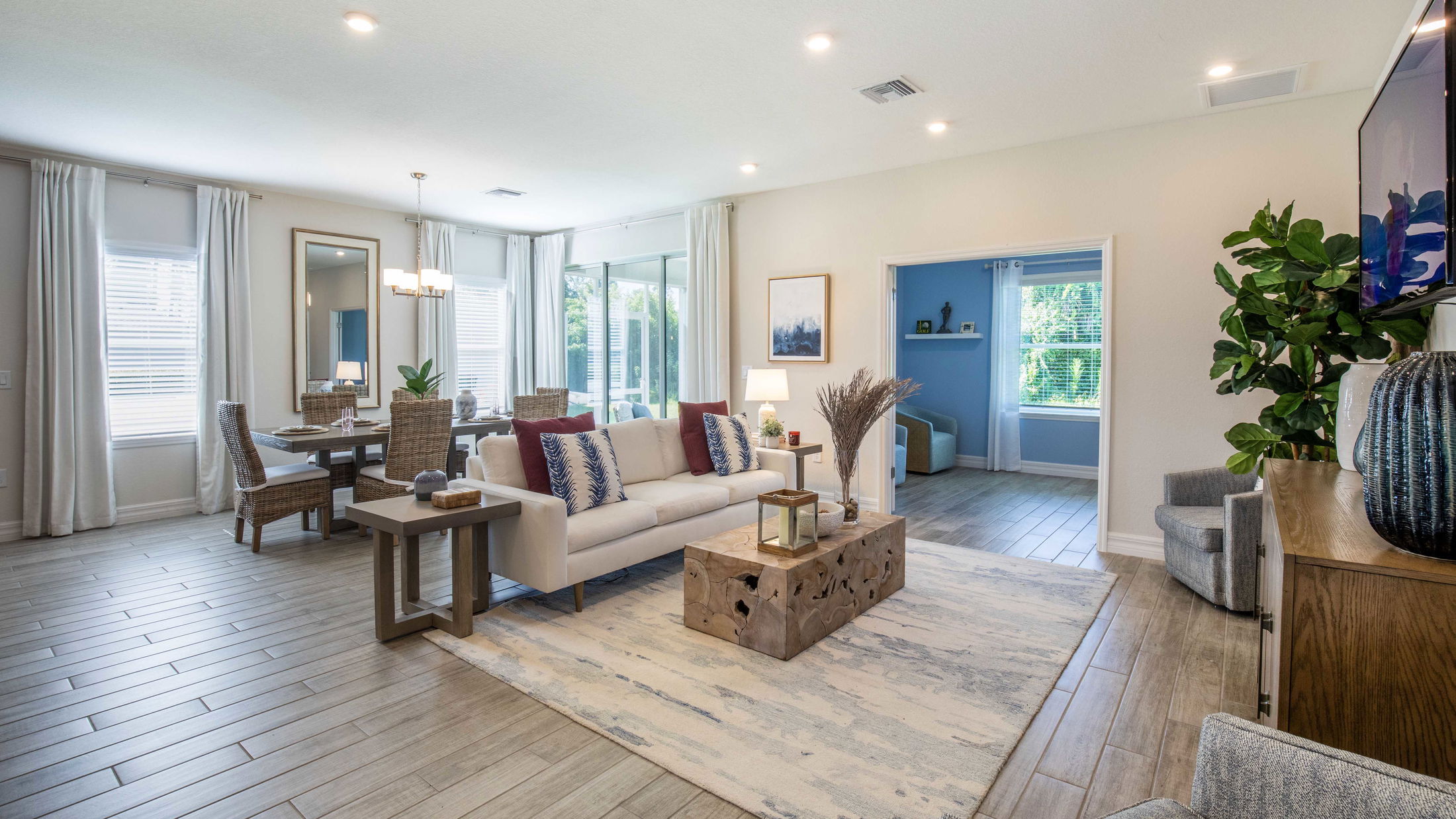 Spacious, modern living room with a stylish dining area, featuring a neutral color palette, large windows, and elegant furnishings.