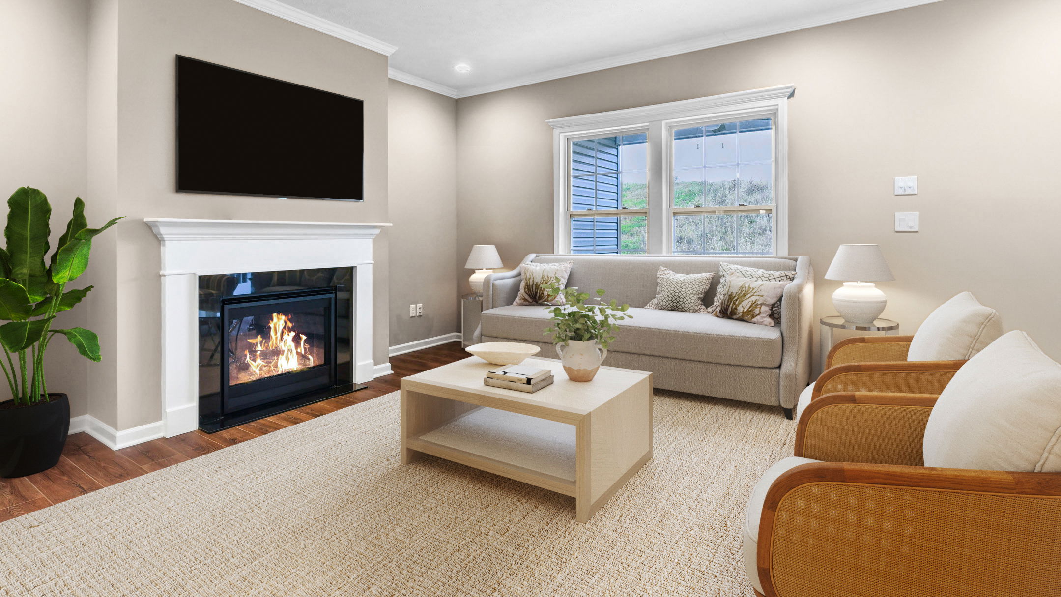 A cozy living room with a modern fireplace, neutral decor, and a large window, featuring a beige sofa and two stylish chairs.