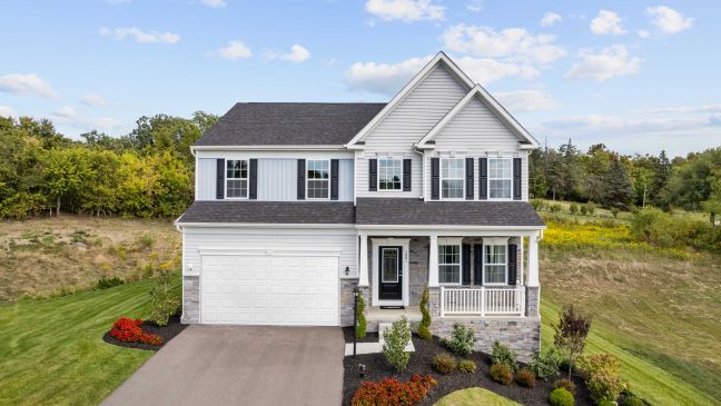 Modern two-story suburban house with a well-maintained lawn, white siding, and attached garage on a sunny day.