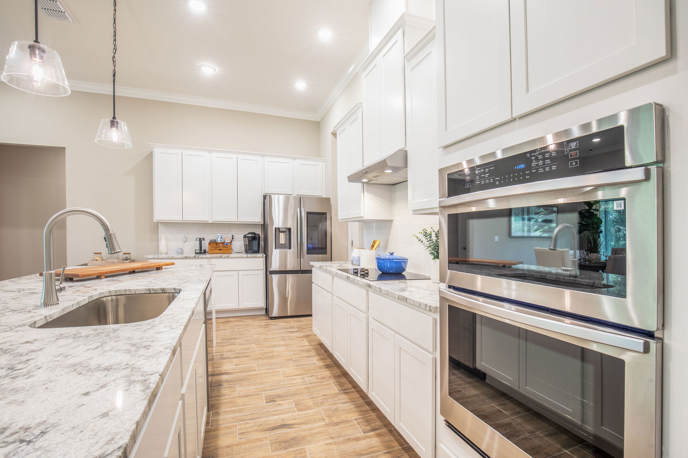 Modern kitchen with white cabinets, stainless steel appliances, and granite countertops.