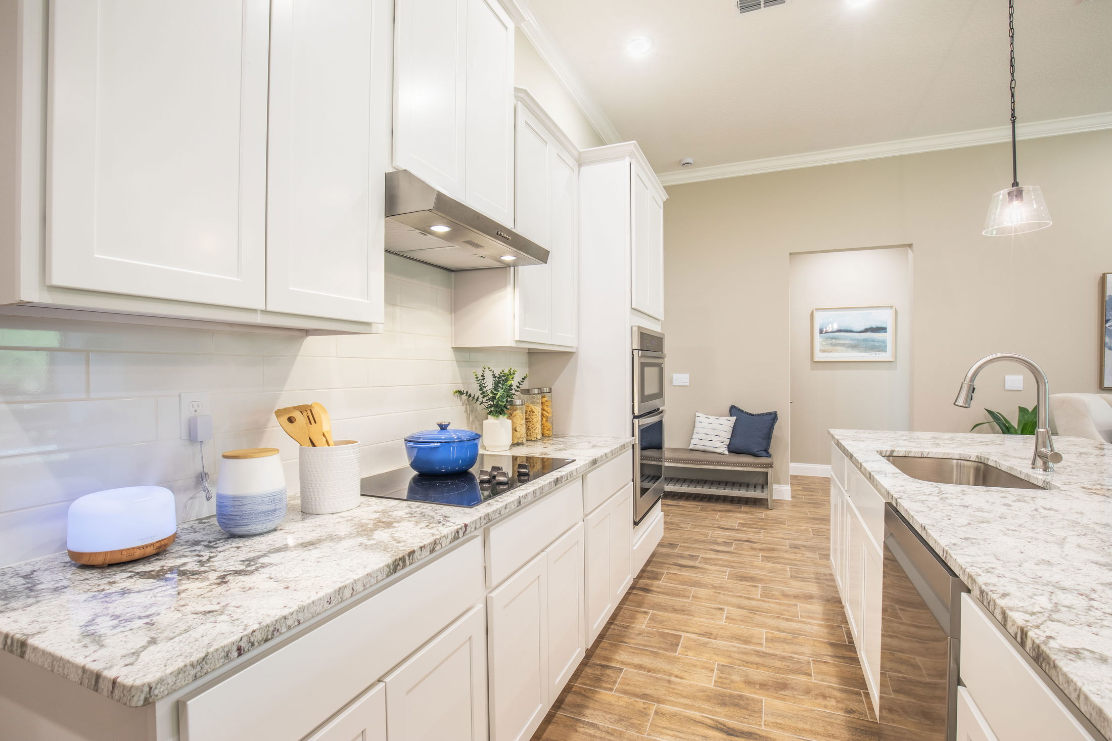 Modern kitchen with white cabinets, granite countertops, and a sleek stainless steel oven.