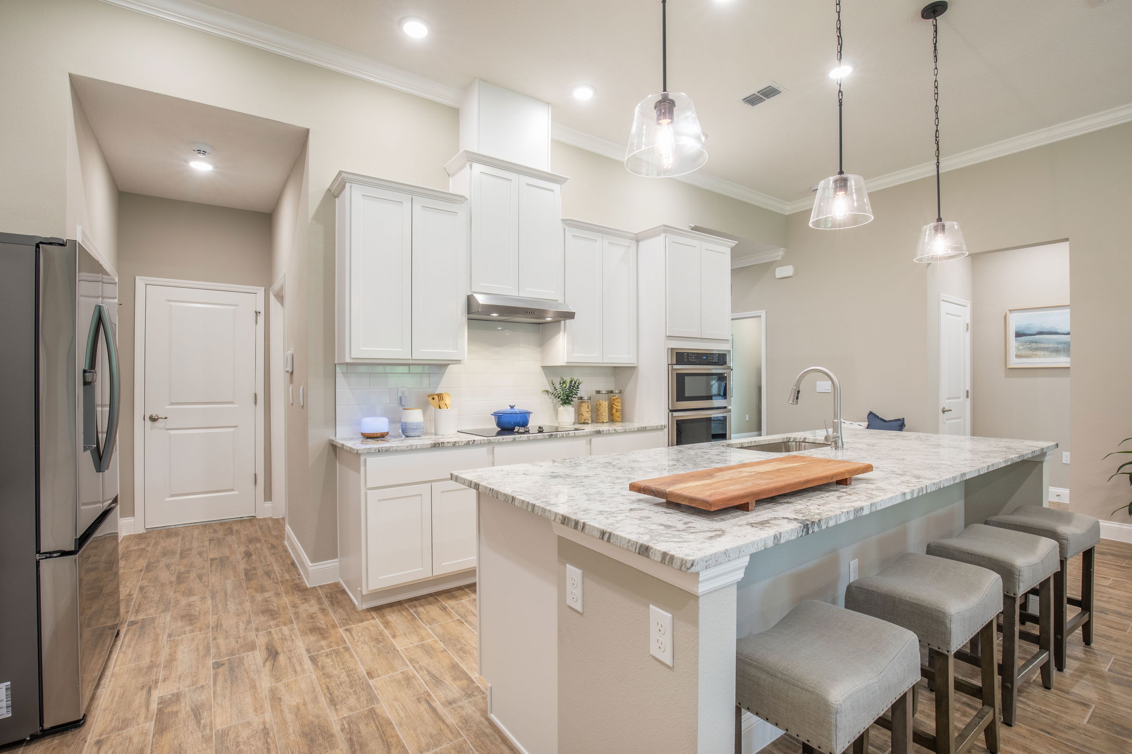 Modern kitchen with white cabinets, granite countertops, and stainless steel appliances.