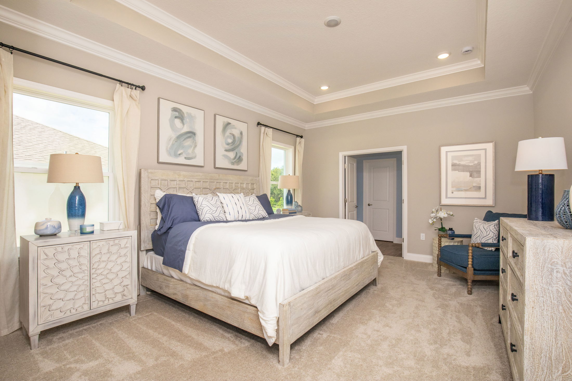 Elegant master bedroom with neutral tones, featuring a king-size bed, stylish decor, and natural lighting.