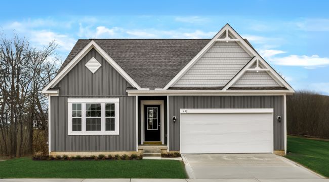 Modern gray single-story house with a gabled roof and attached white garage in a suburban setting.