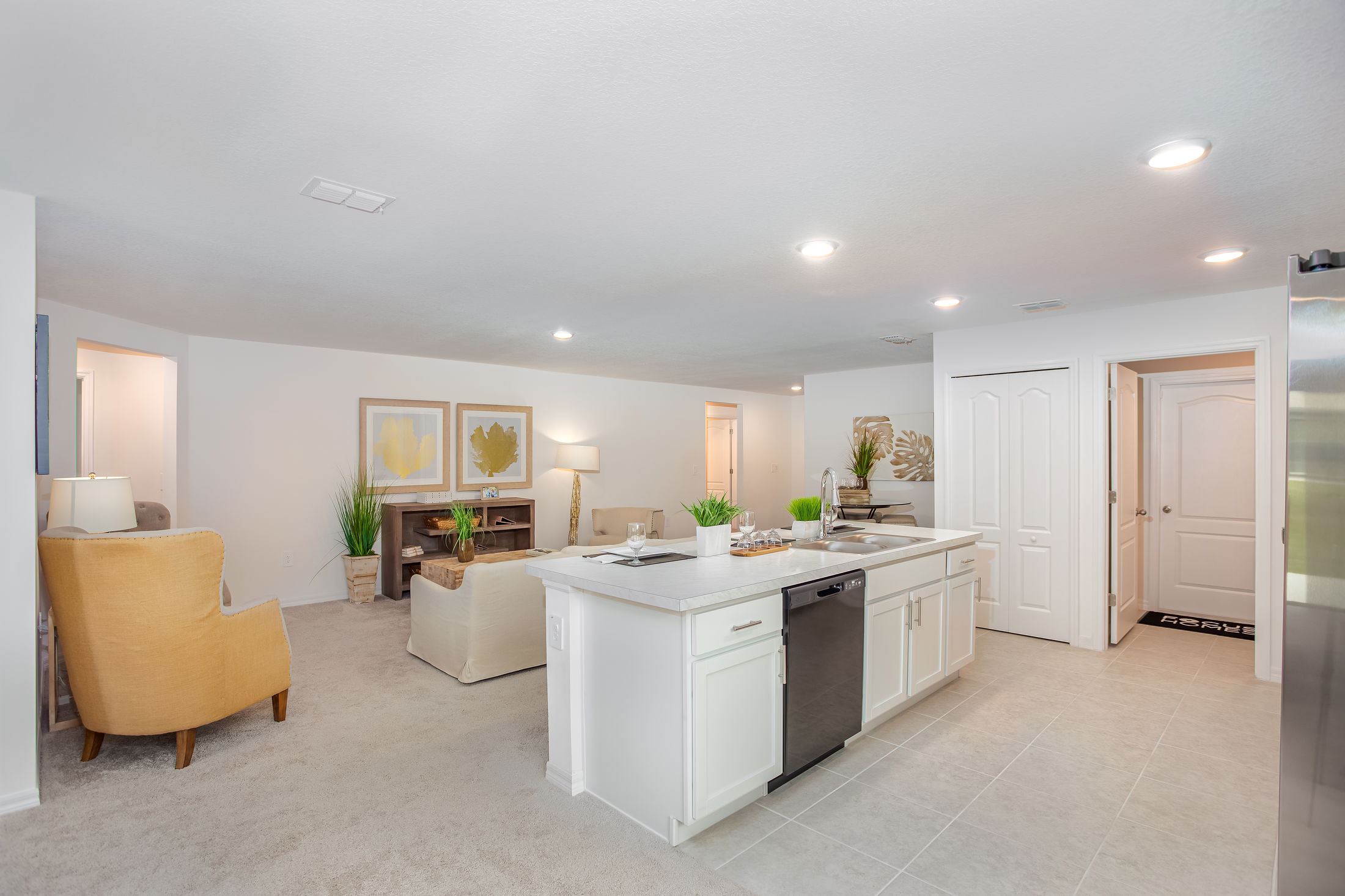Modern open-concept living room and kitchen with neutral tones and elegant decor.